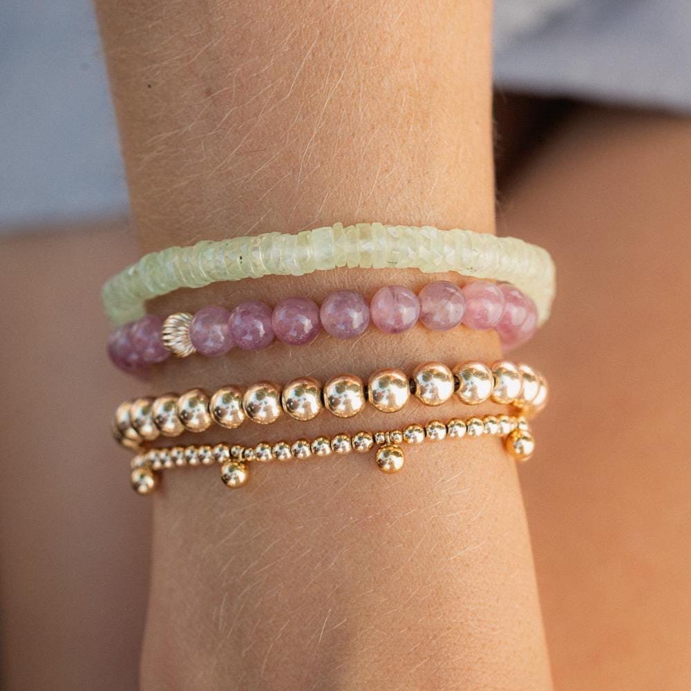 Madagascar Rose Quartz bracelet by Earthly Abundance featuring polished pink quartz beads on an elastic cord.