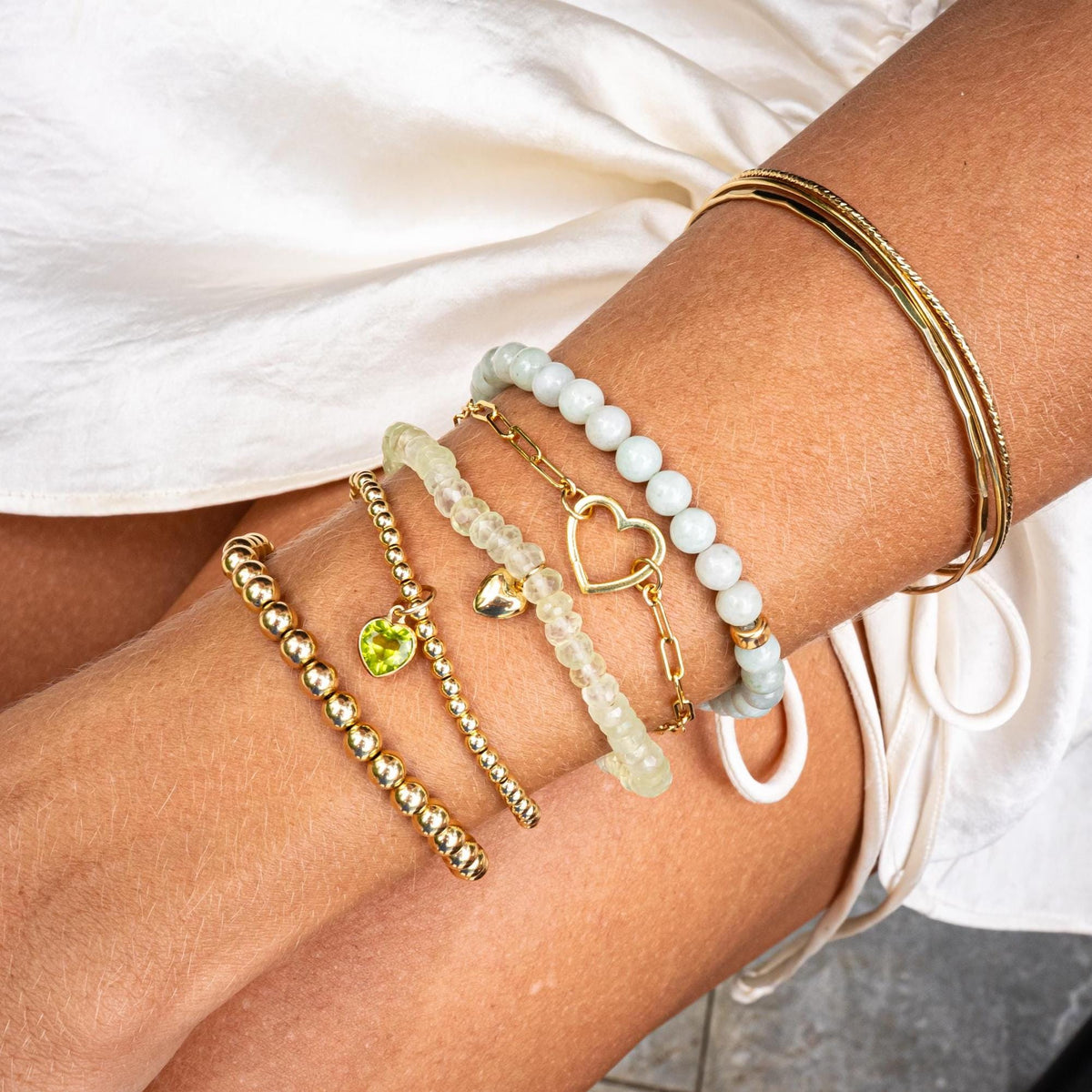 Set of gold-filled bangles featuring smooth, hammered, and sparkly finishes from Earthly Abundance, shown in a close-up image.