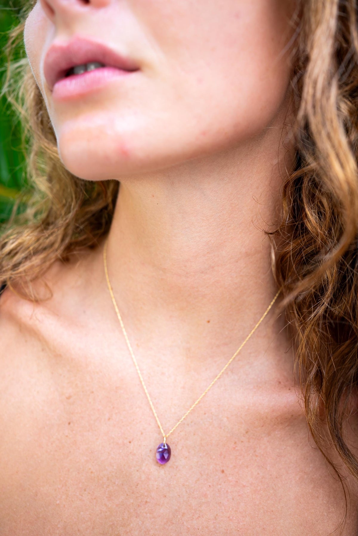 Brazilian Amethyst pendant necklace in 14K gold, featuring a polished purple amethyst gemstone and gold chain.