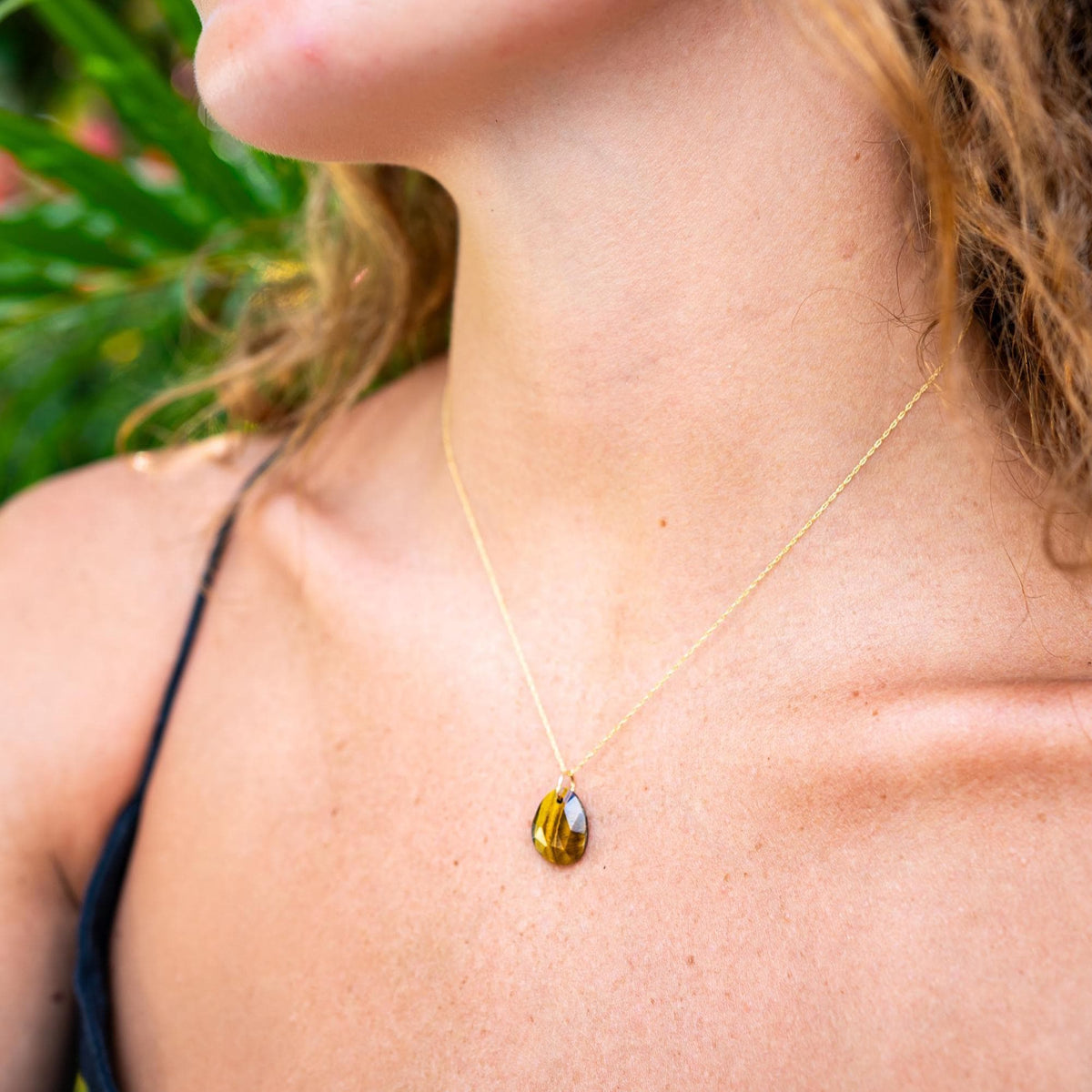 Tiger's eye pendant from Earthly Abundance featuring a polished, oval-shaped gemstone on a silver chain.