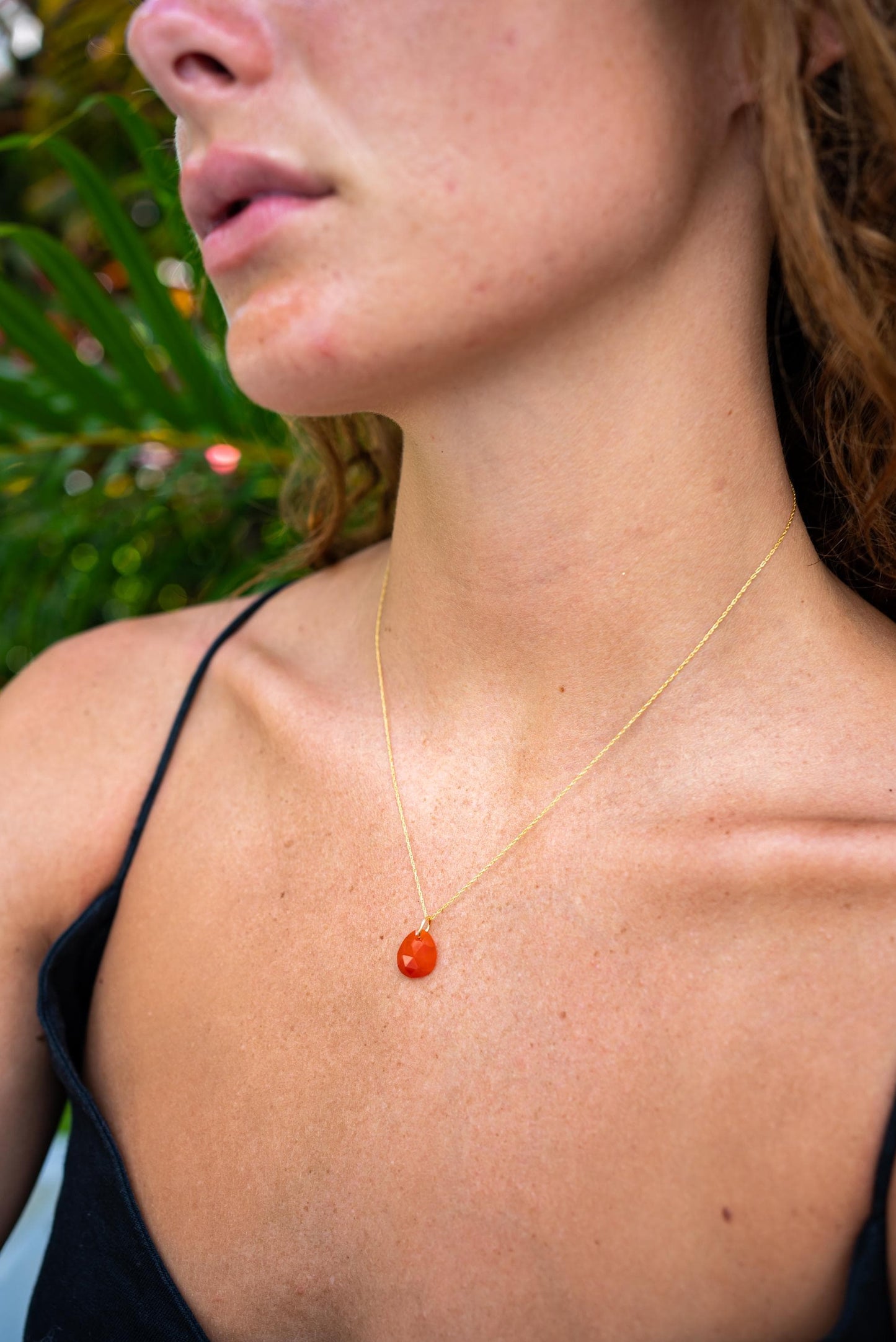 Earthly Abundance Carnelian pendant necklace featuring a polished orange-red gemstone on a delicate chain.