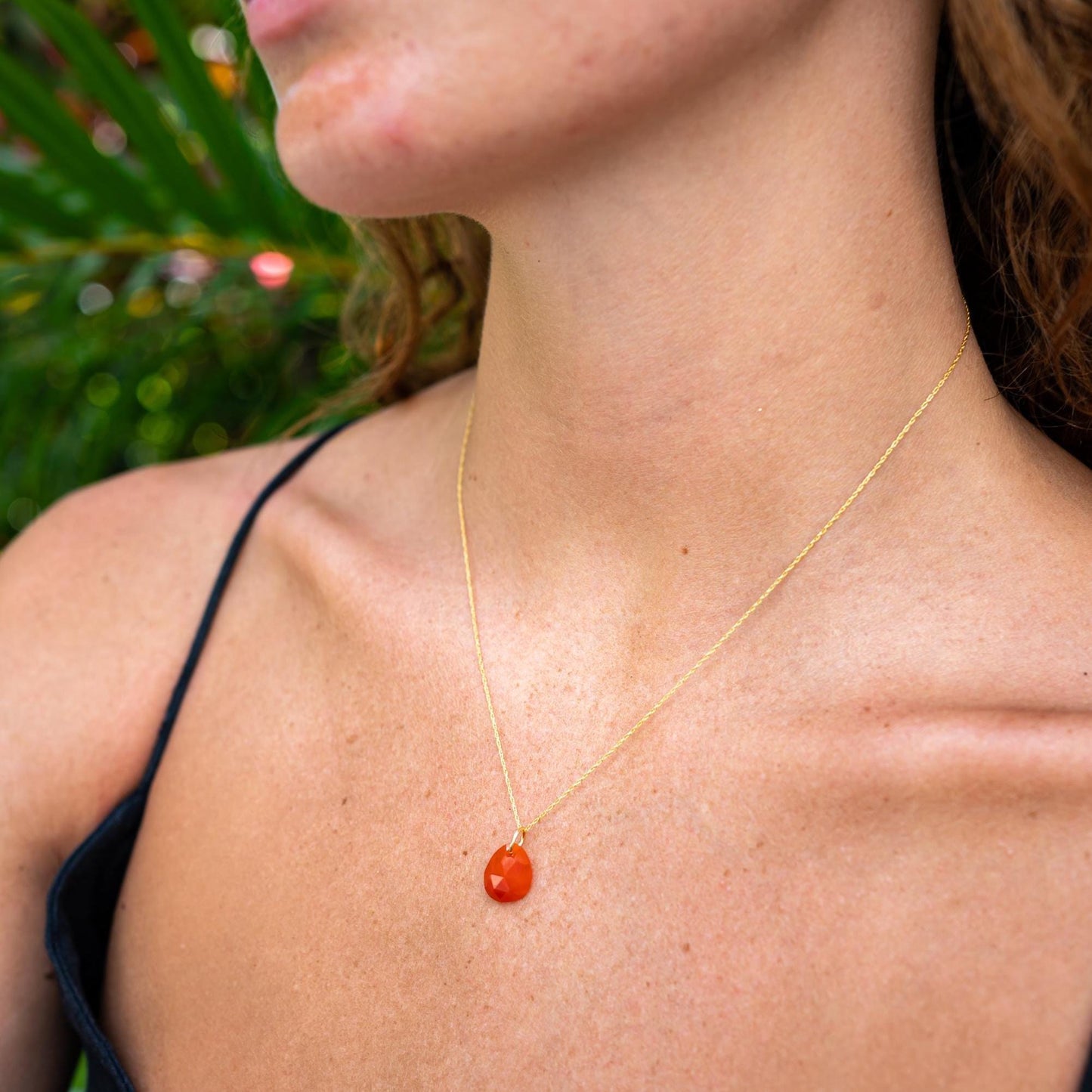 Earthly Abundance Carnelian pendant necklace featuring a polished orange-red gemstone on a delicate chain.