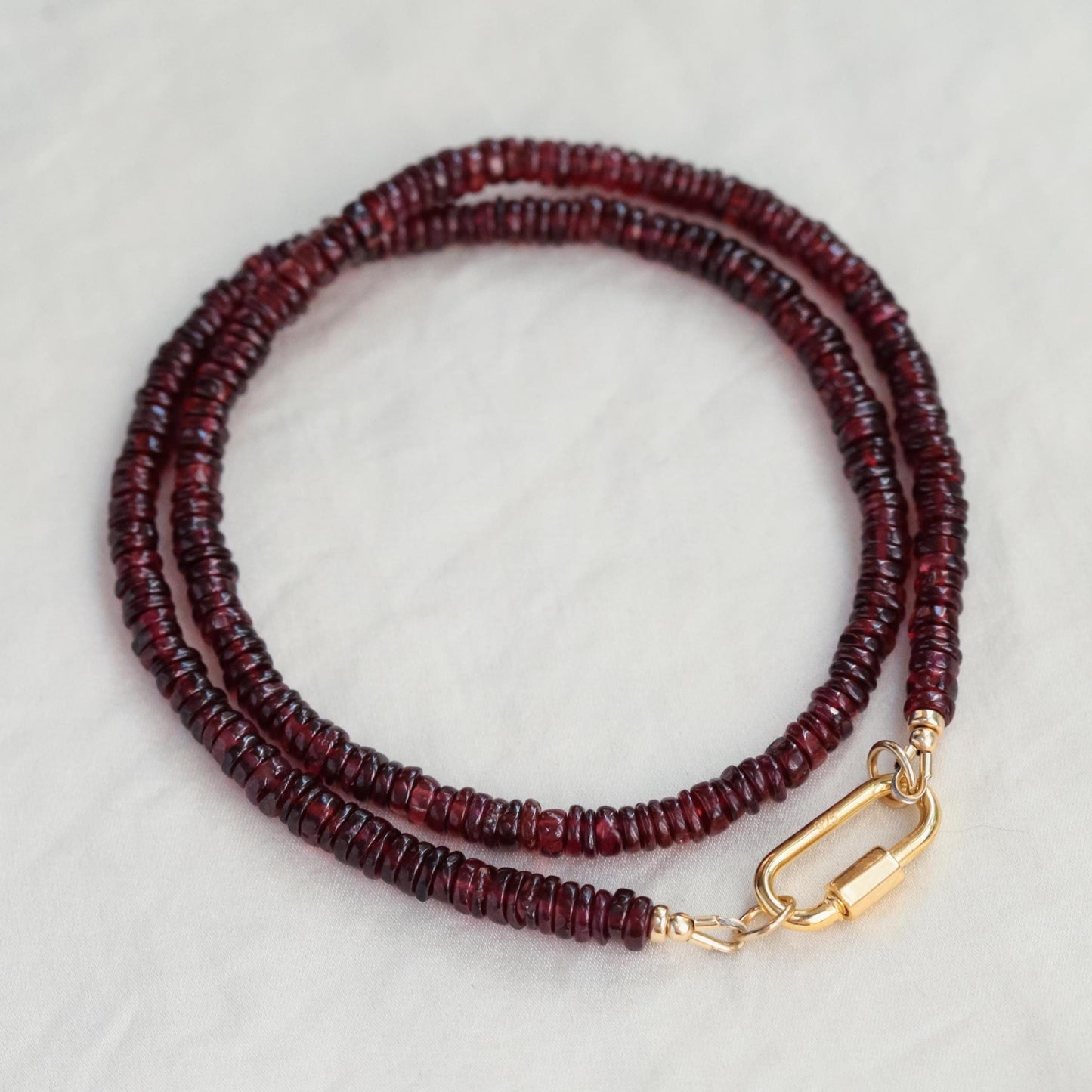 Earthly Abundance garnet beaded necklace with red gemstone beads on a delicate chain, close-up view of the jewelry.