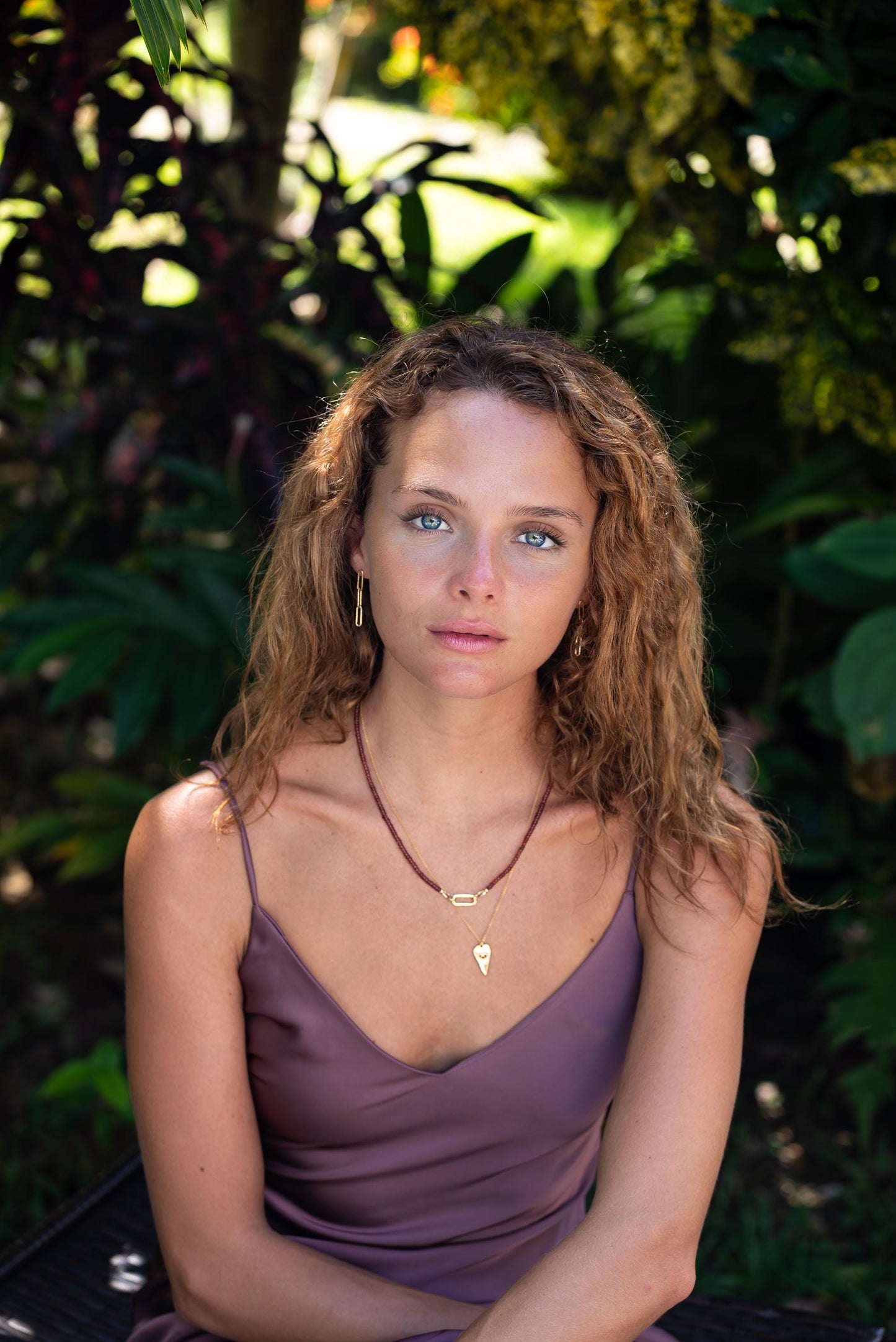 Garnet carabiner necklace with a silver chain from Earthly Abundance, featuring a polished garnet gemstone pendant.