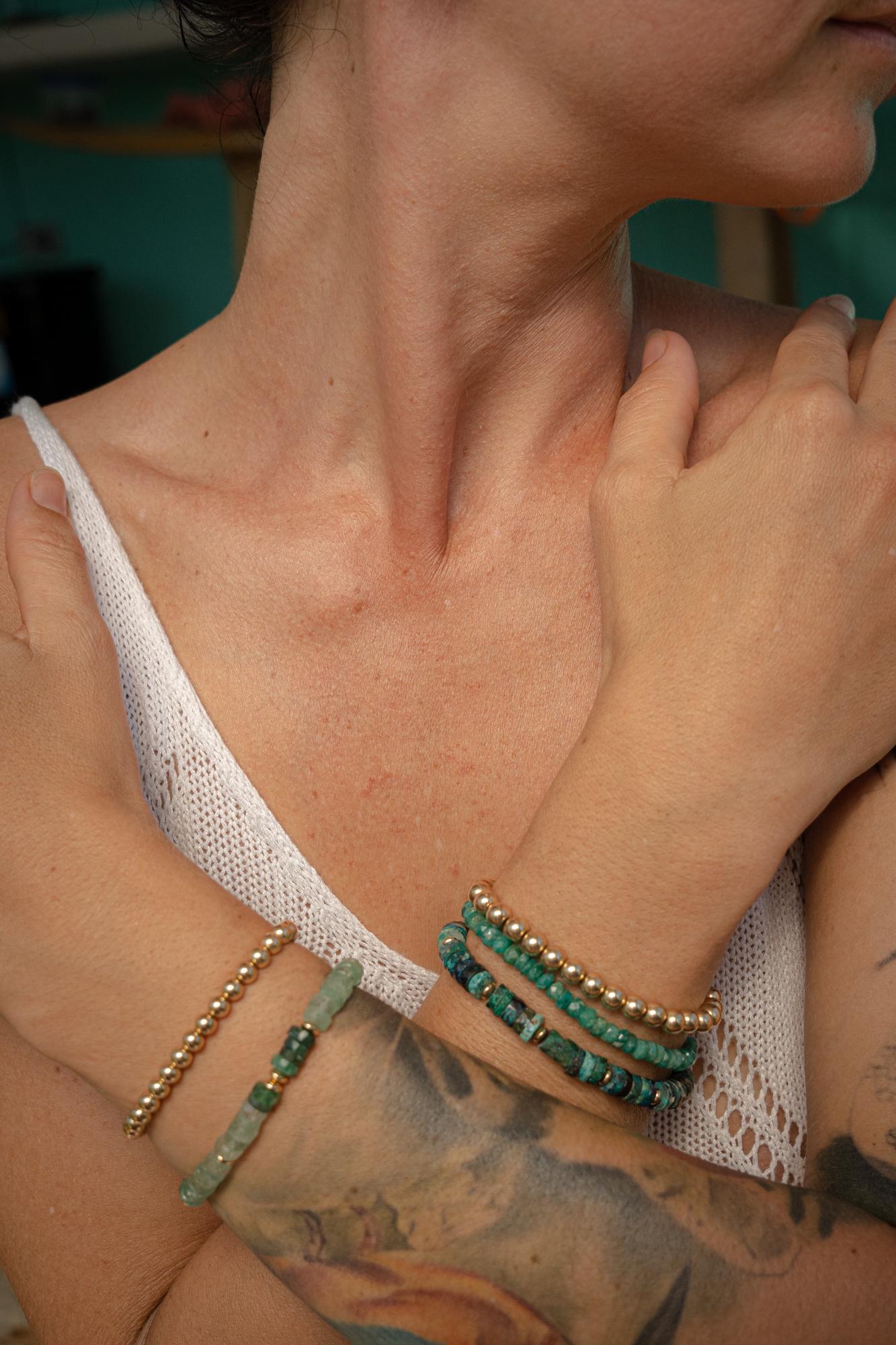 Heart-centered Amazonite bracelet featuring smooth blue-green stones, accented with silver spacer beads, on a soft fabric background.