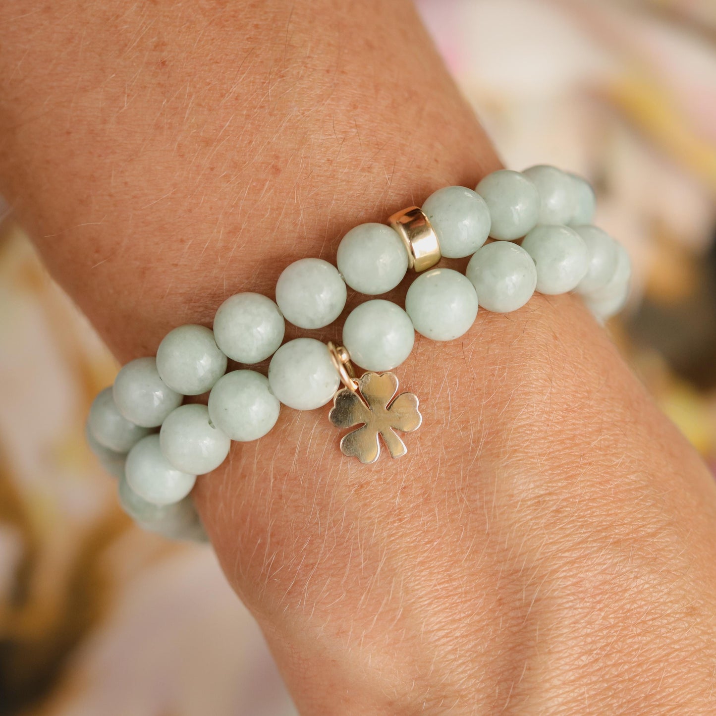 Jadeite Clover bracelet by Earthly Abundance featuring green jadeite beads and a four-leaf clover charm on an elastic band.