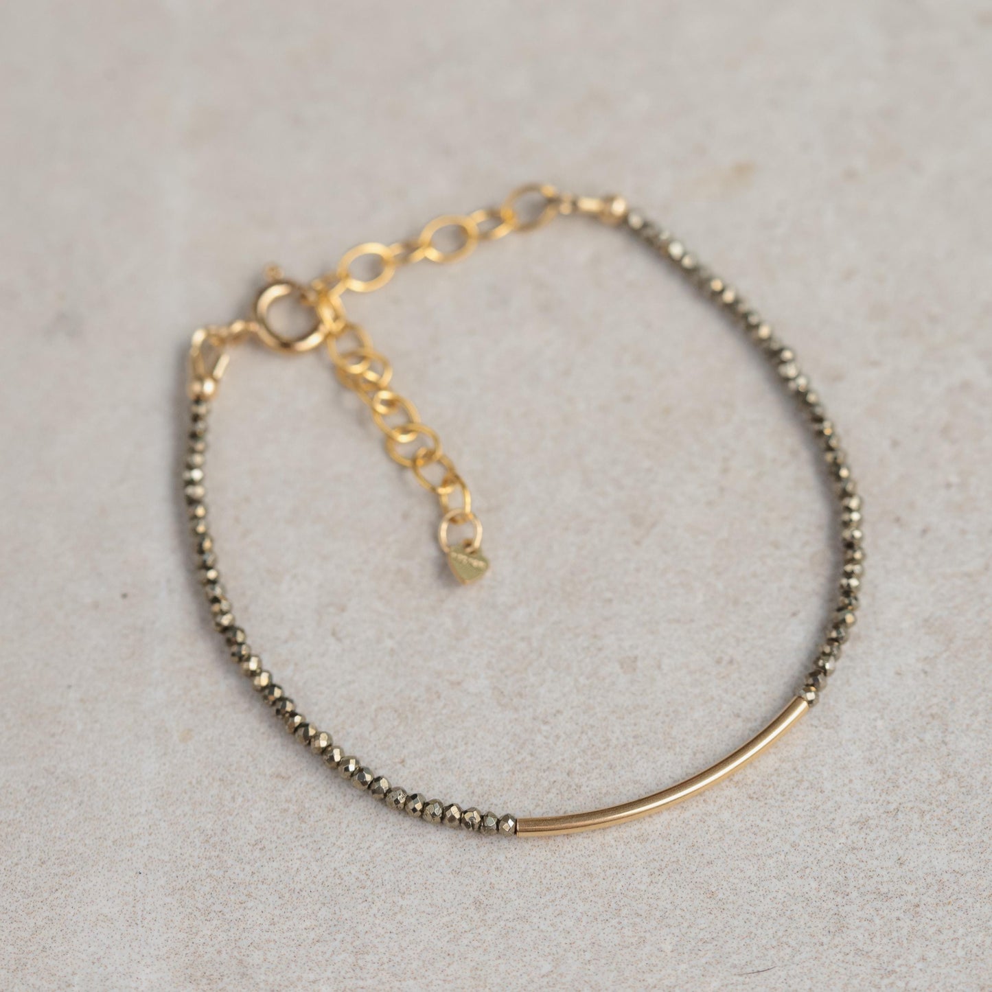 Earthly Abundance Pyrite bracelet with polished beads, showcasing metallic gold tones and natural stone texture on a neutral background.