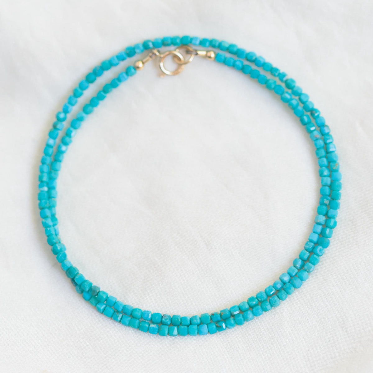 Turquoise cube necklace from Earthly Abundance featuring a vibrant turquoise stone pendant on a silver chain.