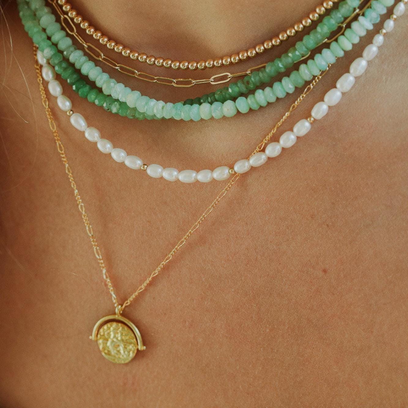 Freshwater pearl necklace with 14K gold clasp from Earthly Abundance Jewelry, showcasing lustrous white pearls on a delicate chain.