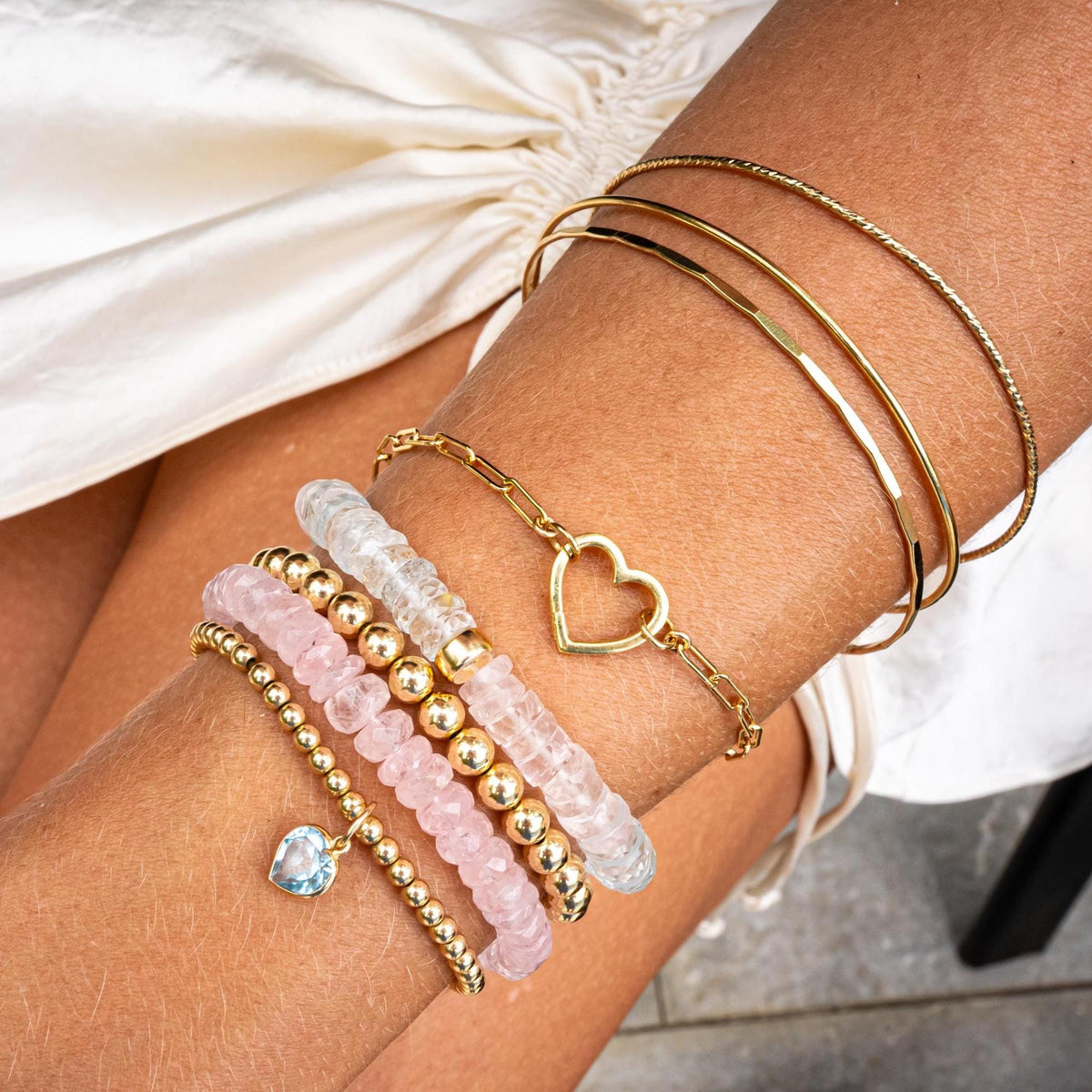 Set of Earthly Abundance gold-filled bangles with smooth, hammered, and sparkly finishes, stacked and displayed on a neutral background.