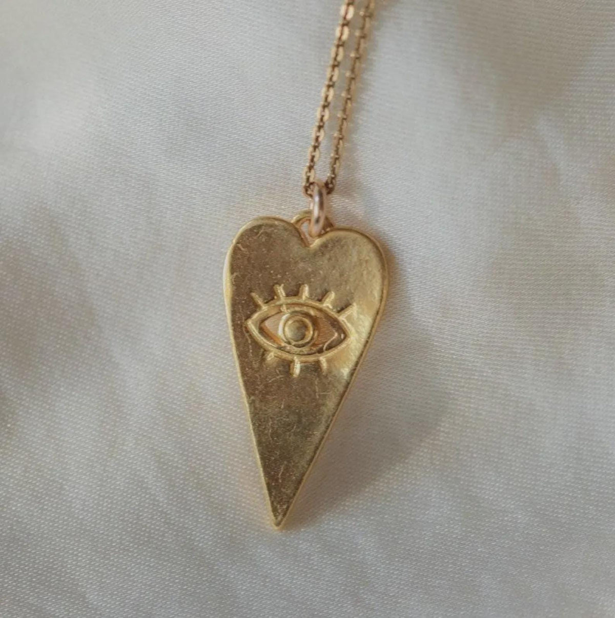 Gold vermeil pendant from Earthly Abundance featuring intricate design, hanging on a delicate chain against a neutral background.