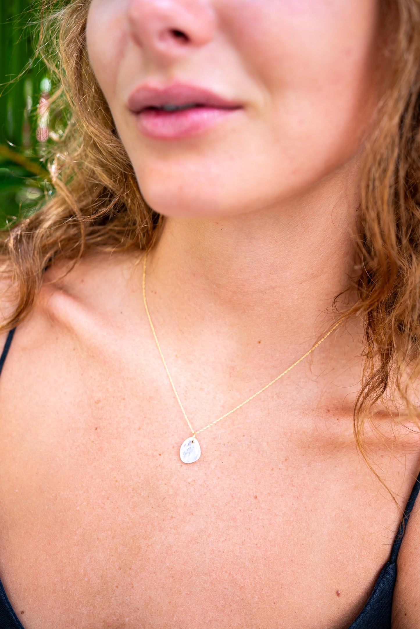 Rainbow Moonstone pendant necklace in 14K gold with a polished, iridescent moonstone gemstone on a delicate chain.