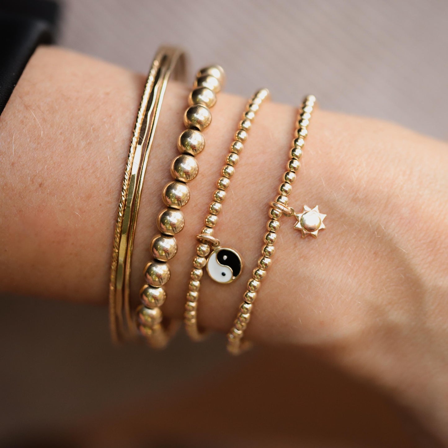 Earthly Abundance Yin Yang charm bracelet featuring black and white beads with yin yang pendant on a delicate chain.
