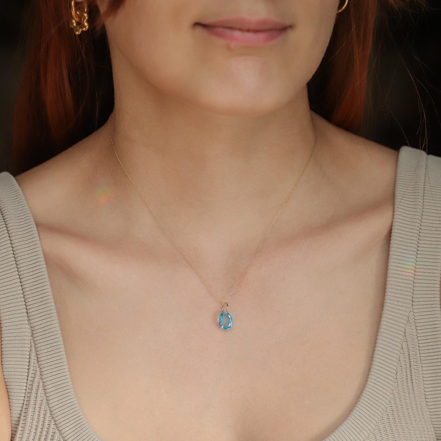 Swiss blue topaz pendant in 14K gold from Earthly Abundance, showcasing a vibrant blue gemstone set in a elegant gold pendant.