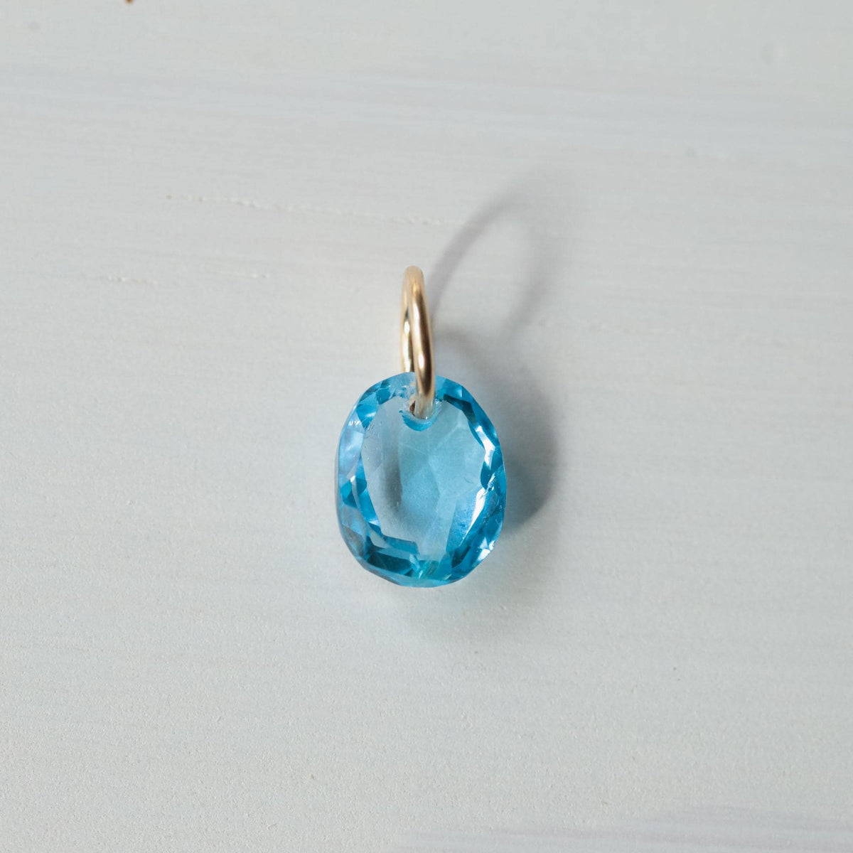 Swiss blue topaz pendant in 14K gold setting, showcasing a vibrant blue gemstone with elegant gold accents.