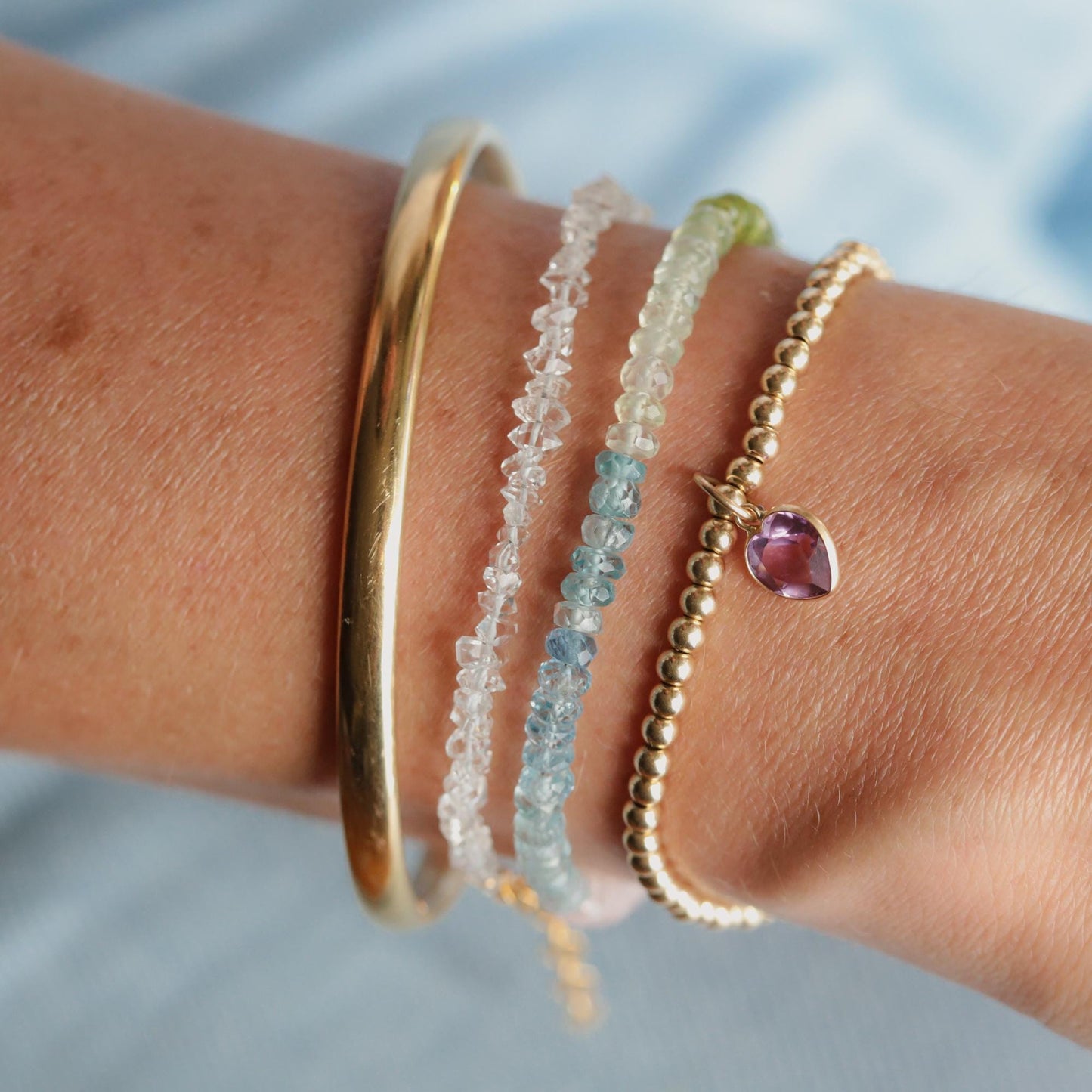 Vibrant gemstone jewelry featuring peridot, prehnite, aquamarine, blue zircon, and morganite set in 14K gold filled from Earthly Abundance