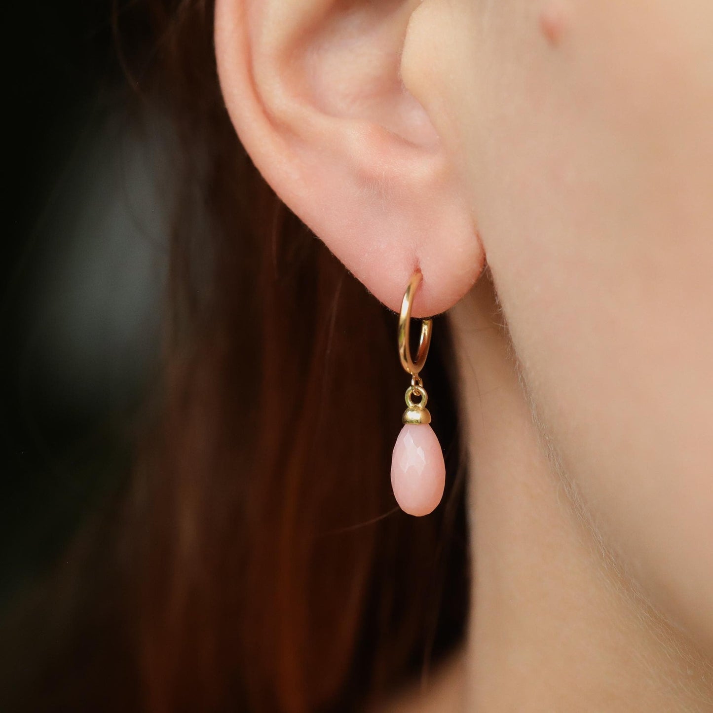 Pink Opal Hoop Earrings by Earthly Abundance featuring pink opal stones and gold-tone hoops on a white background.
