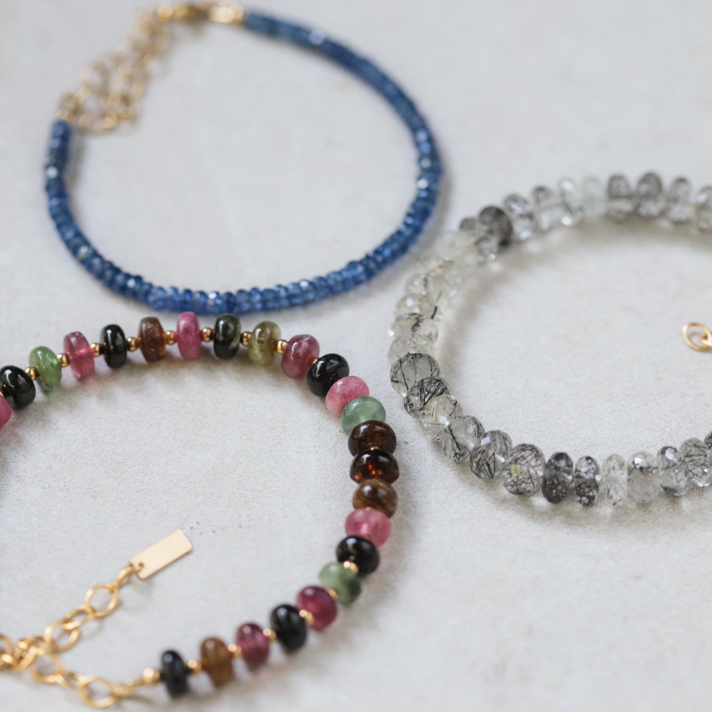 Black rutilated quartz bracelet with magnetic clasps from Earthly Abundance, featuring polished beads and intricate golden rutile inclusions.