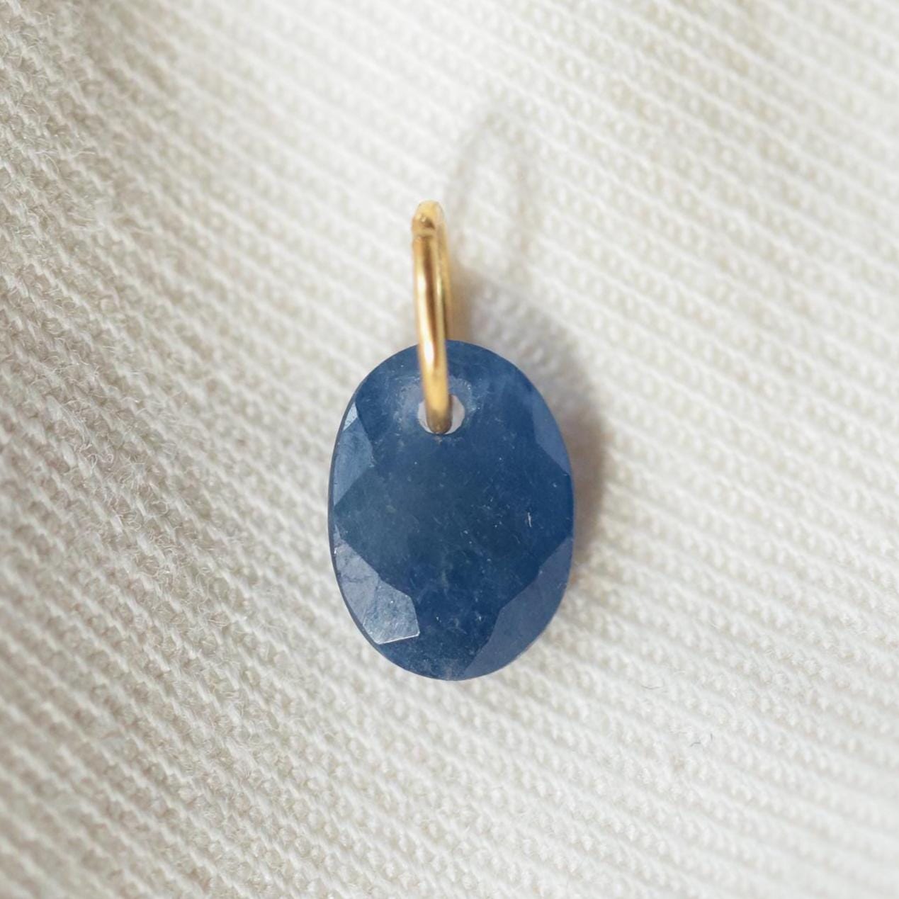 Blue sapphire pendant necklace in 14K gold with intricate design, featuring a central blue sapphire gemstone.