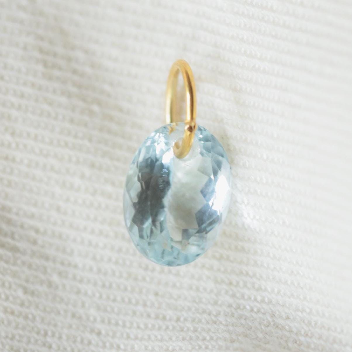 Aquamarine pendant necklace with 14K gold setting, featuring a sparkling blue gemstone, displayed on a chain.