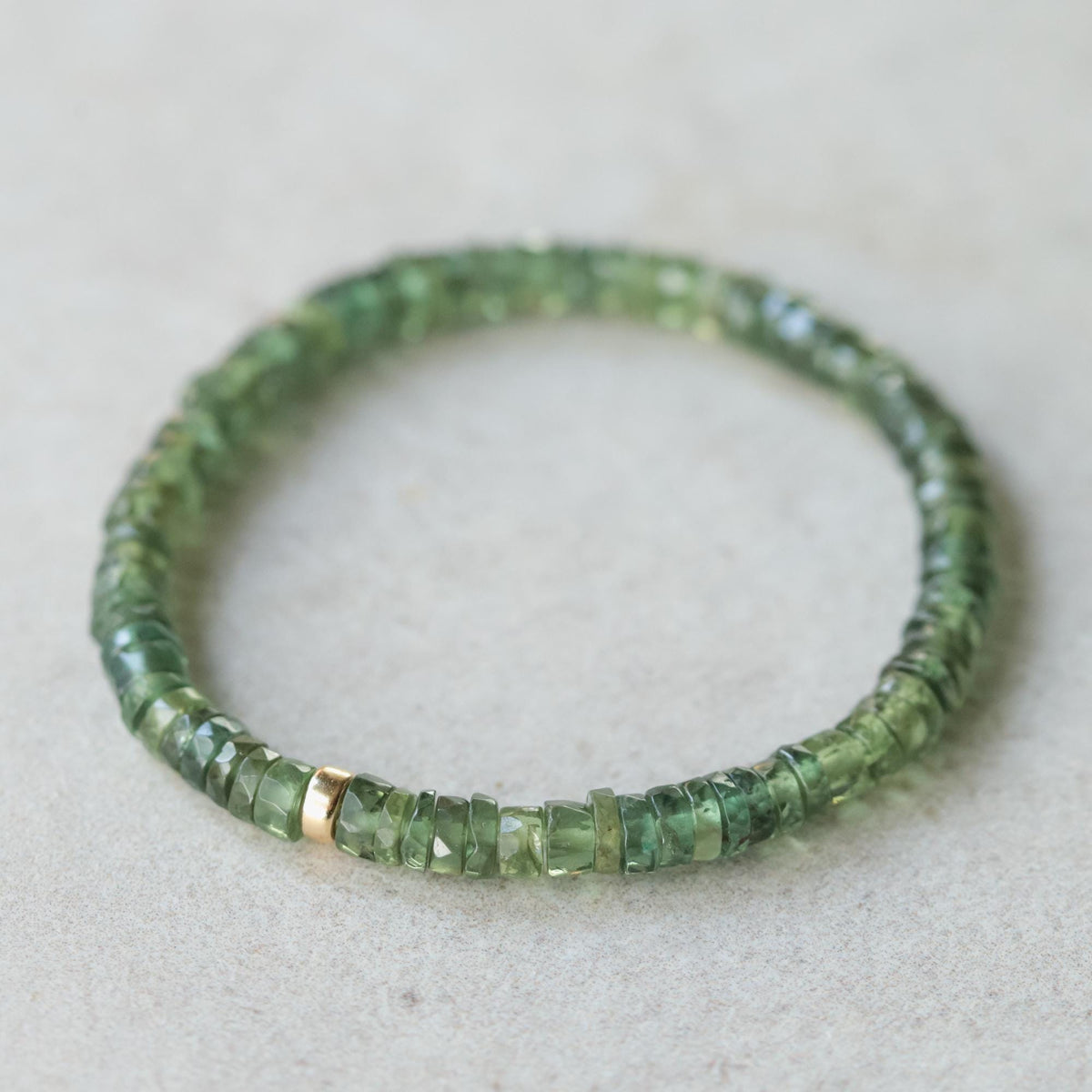 Green Apatite Heishi bracelet with small, round gemstone beads from Earthly Abundance, styled in a casual, layered look.