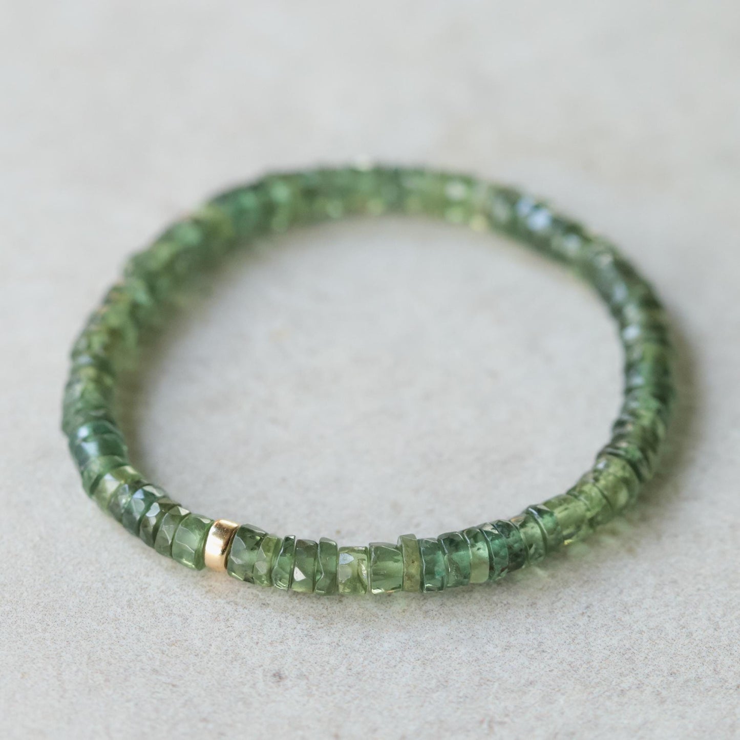 Green Apatite Heishi bracelet from Earthly Abundance featuring small, rounded green stone beads on a stretch cord.