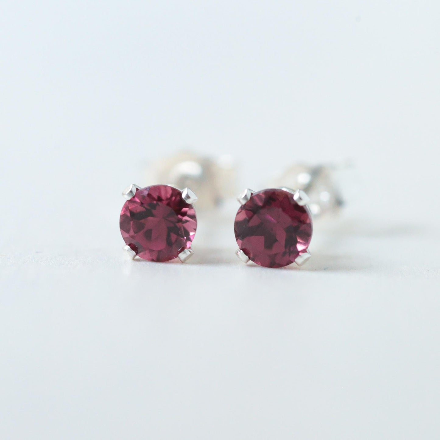 Pink tourmaline stud earring by Earthly Abundance featuring a vibrant pink gemstone set in a simple, elegant metal stud.