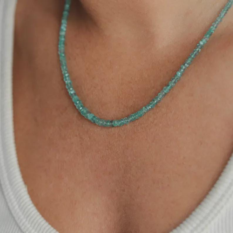 Zambian emerald necklace with 14K gold chain and pendant, featuring a vibrant green emerald gemstone.