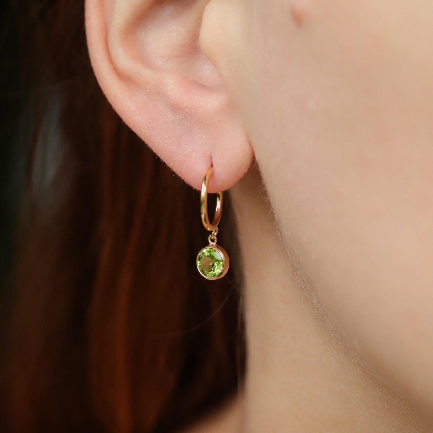 Gold-filled peridot hoop earrings by Earthly Abundance, featuring vibrant green gemstones and classic hoop design.