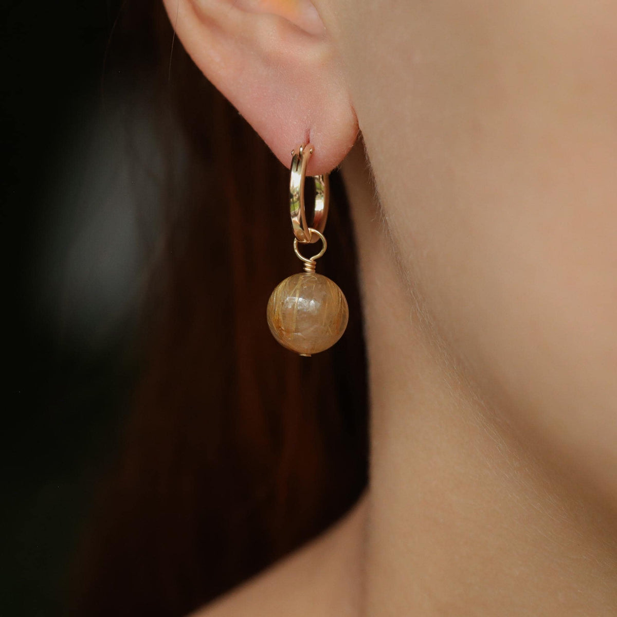 Golden rutilated quartz hoop earrings in 14K gold-filled setting, featuring natural stone details and stylish jewelry design.