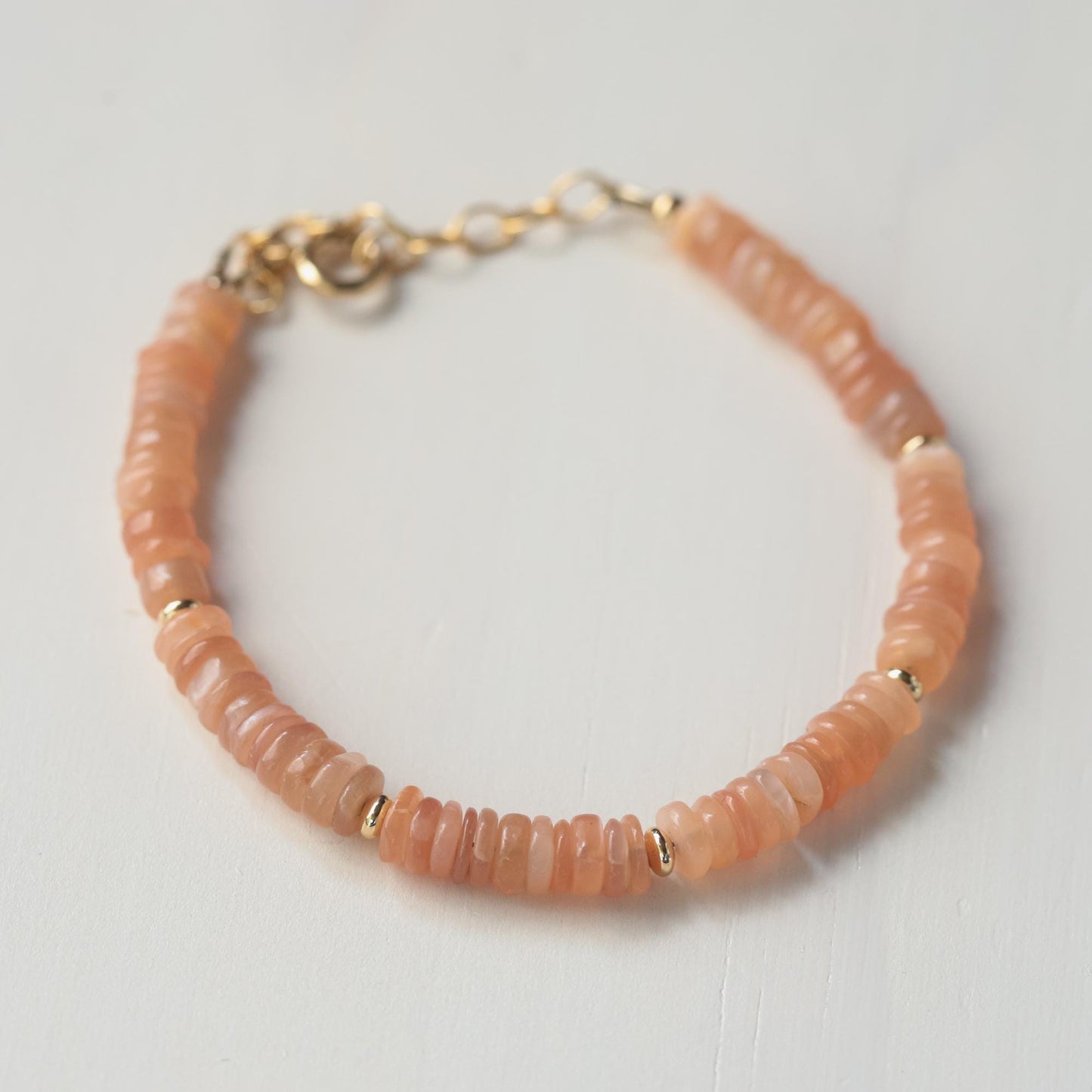 Earthly Abundance Peachy Glow Moonstone bracelet with smooth peach-toned moonstone beads on a delicate elastic band.