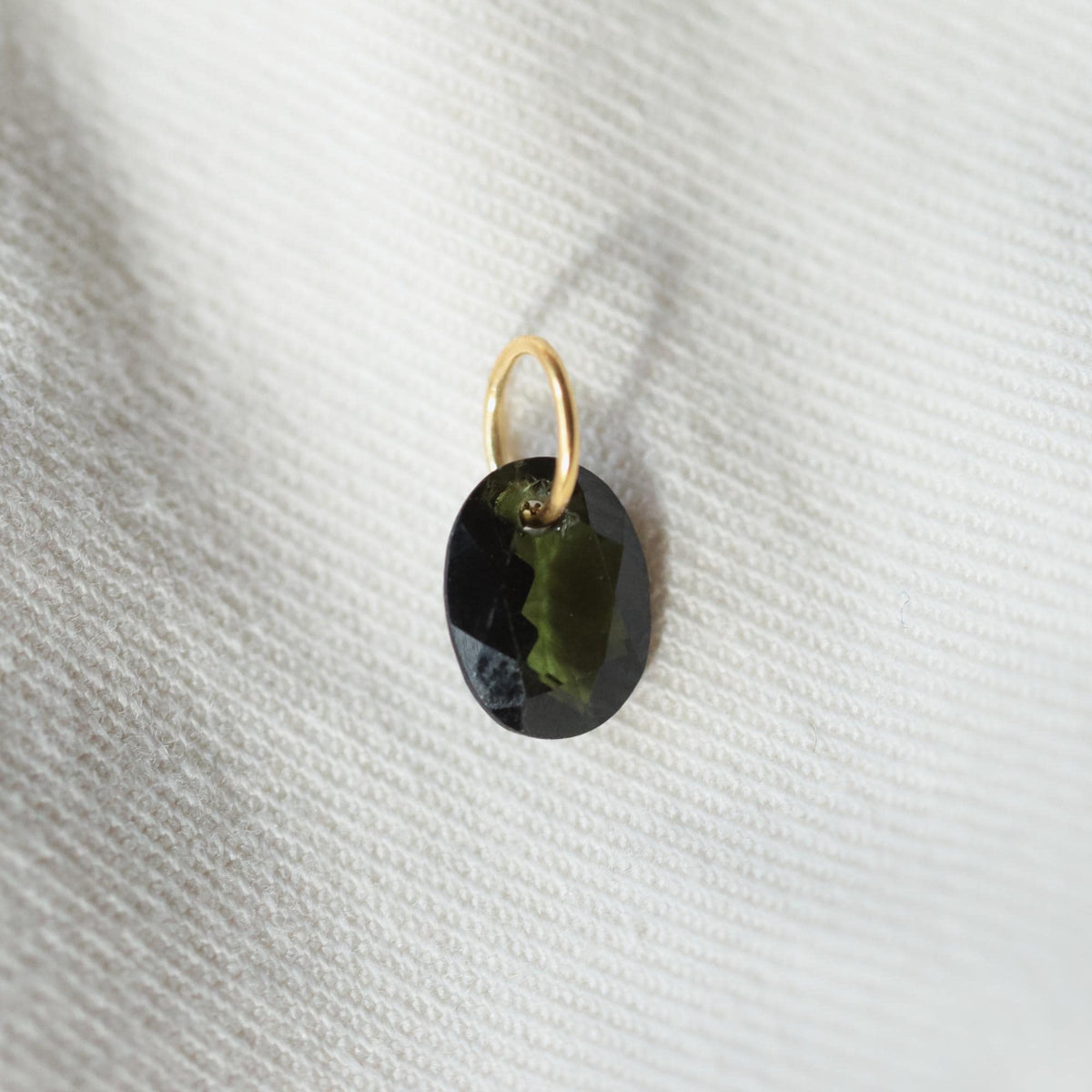 Green tourmaline pendant set in 14K gold, featuring a polished teardrop-shaped stone on a delicate chain.