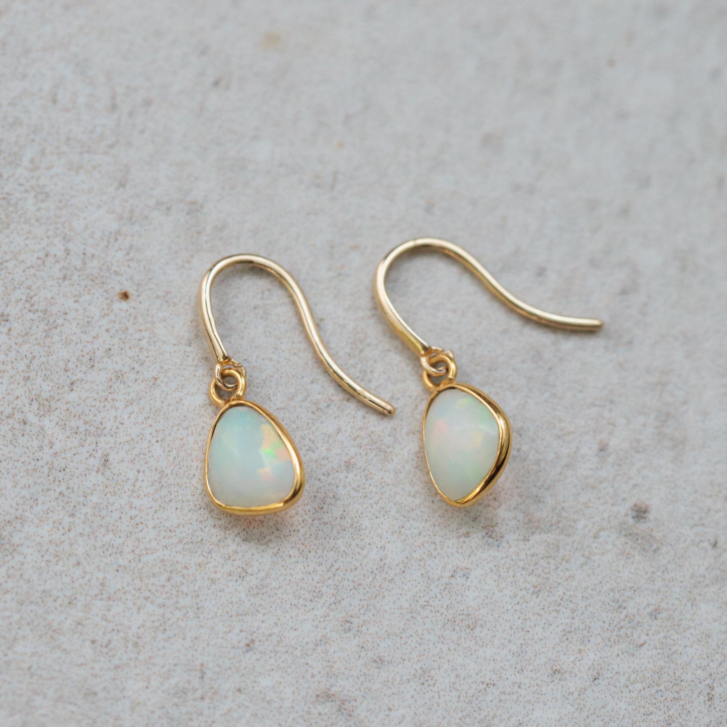 Ethiopian Opal earrings in 14K gold with elegant, effortless design featuring vibrant, iridescent opals and gold hooks.