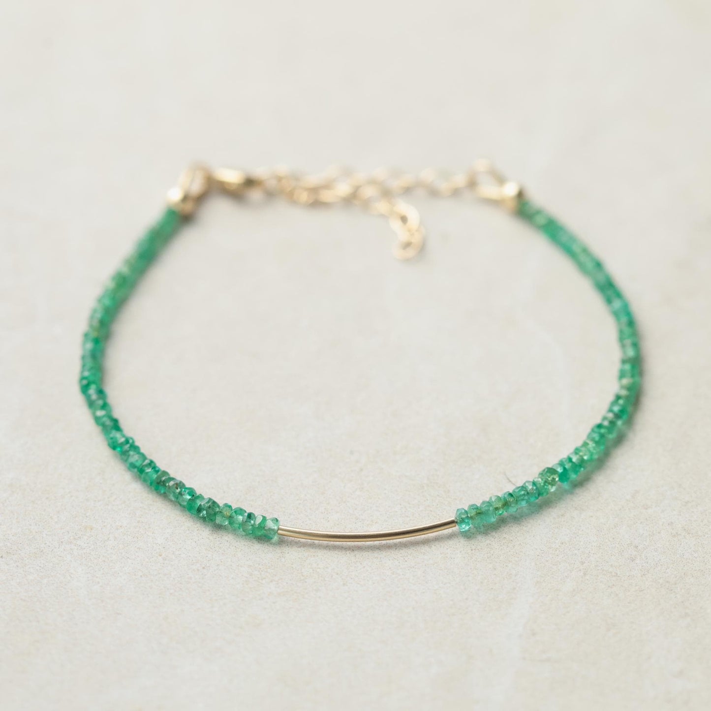 Zambian emerald bracelet with 14K gold setting from Earthly Abundance, featuring vibrant green gemstones on a delicate chain.