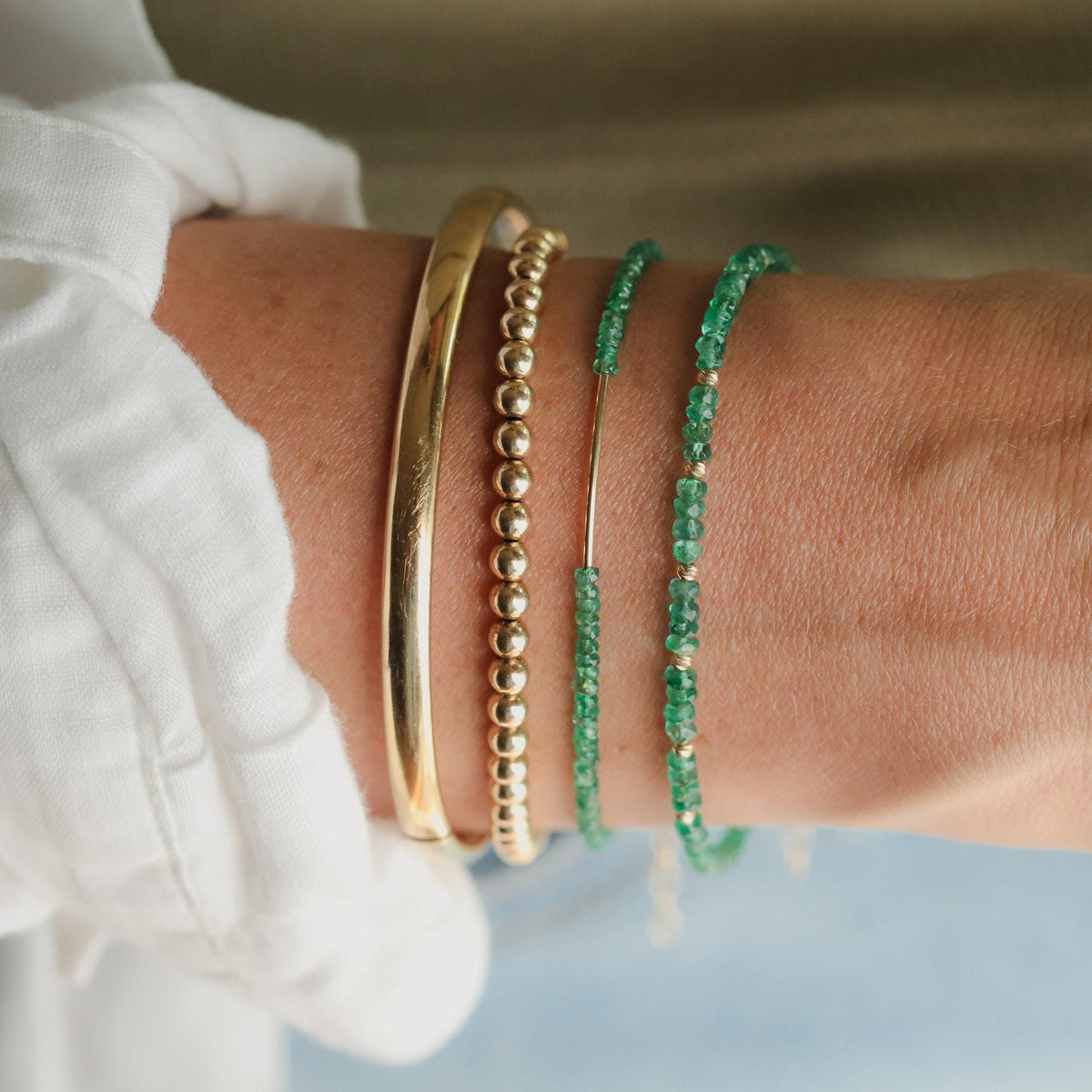 Zambian emerald bracelet with 14K gold setting, featuring vibrant green emeralds on a delicate gold chain.