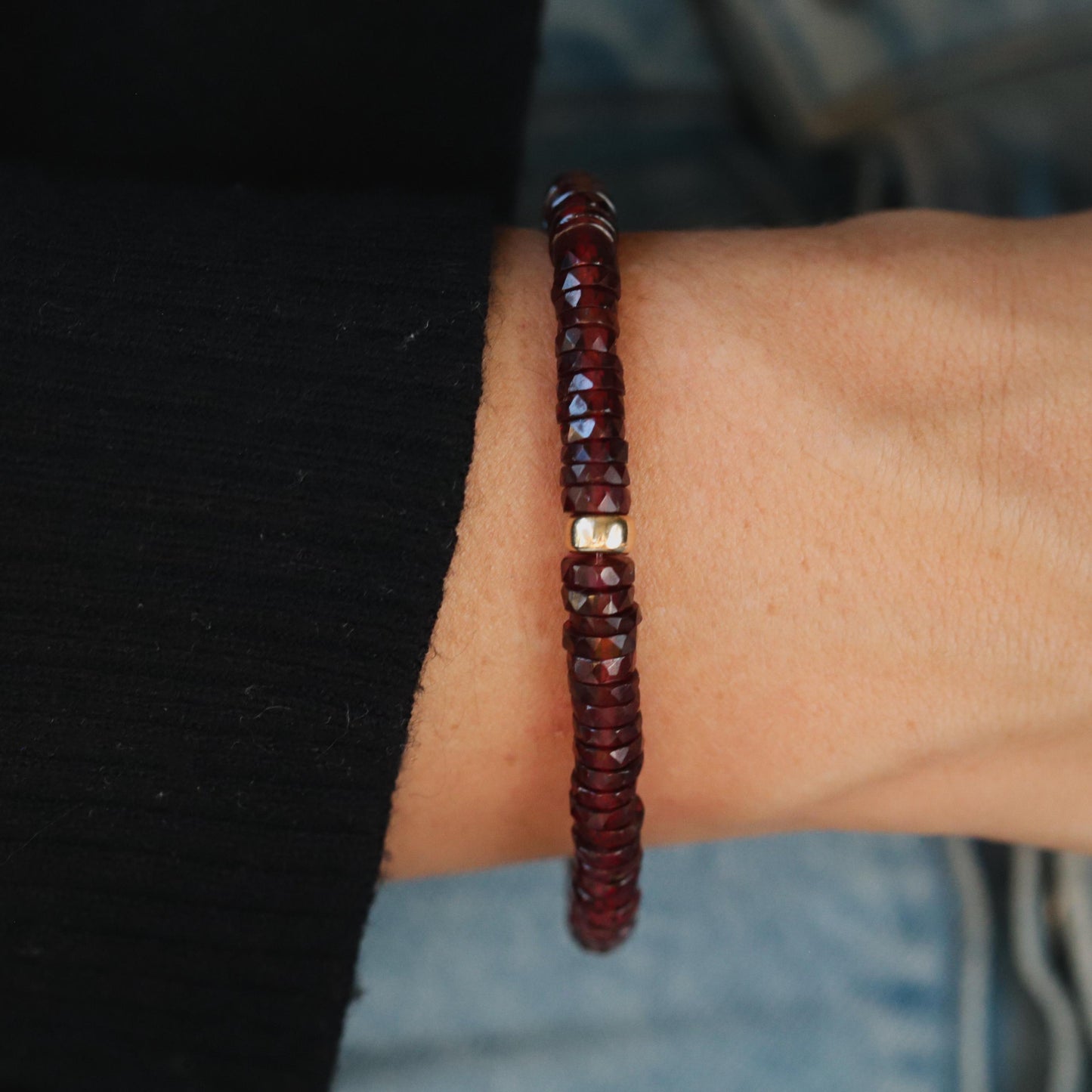 Earthly Abundance garnet Heishi bracelet featuring small red gemstone beads on a stretchy cord.