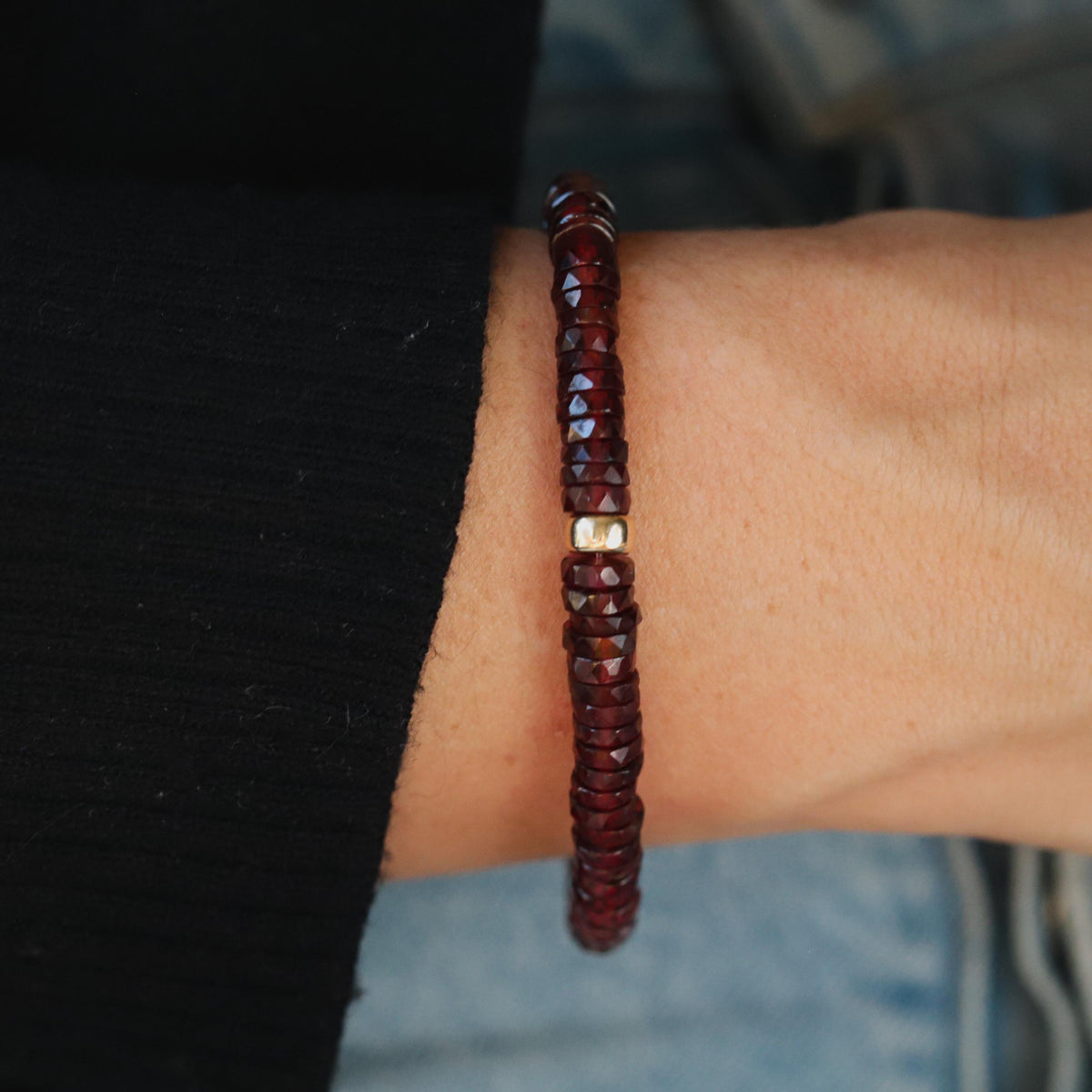 Earthly Abundance garnet Heishi bracelet featuring small red gemstone beads on a stretchy cord.