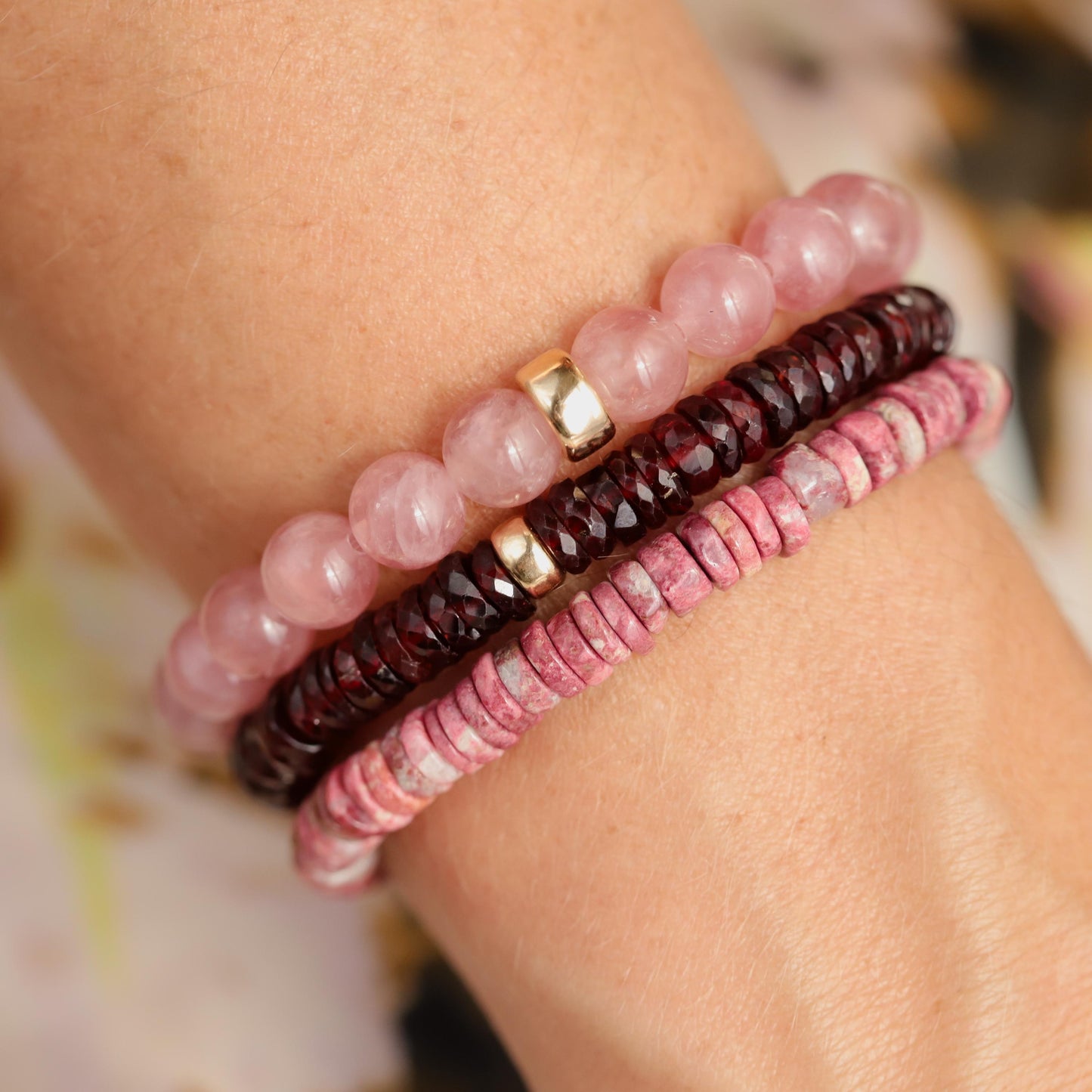 Earthly Abundance garnet Heishi bracelet with small red gemstone beads and elastic band, close-up view of the jewelry.