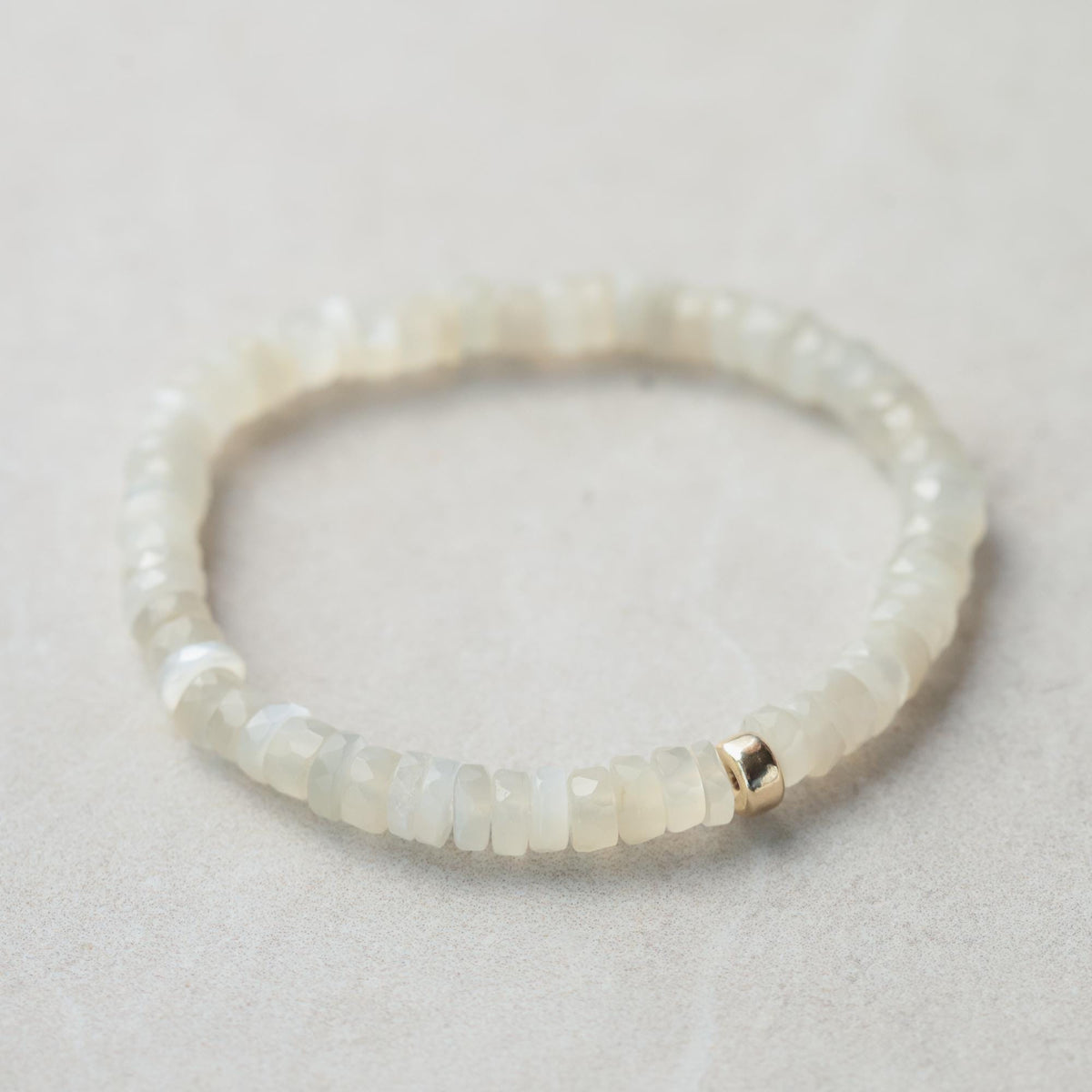 Soft glow moonstone heishi bracelet featuring smooth, round moonstone beads on a delicate elastic band, crafted by Earthly Abundance.