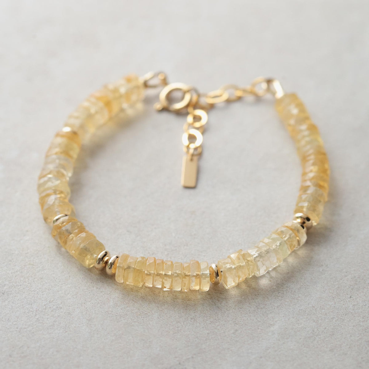 Earthly Abundance radiant citrine heishi bracelet with polished round beads on a delicate string, showcasing warm yellow gemstones.