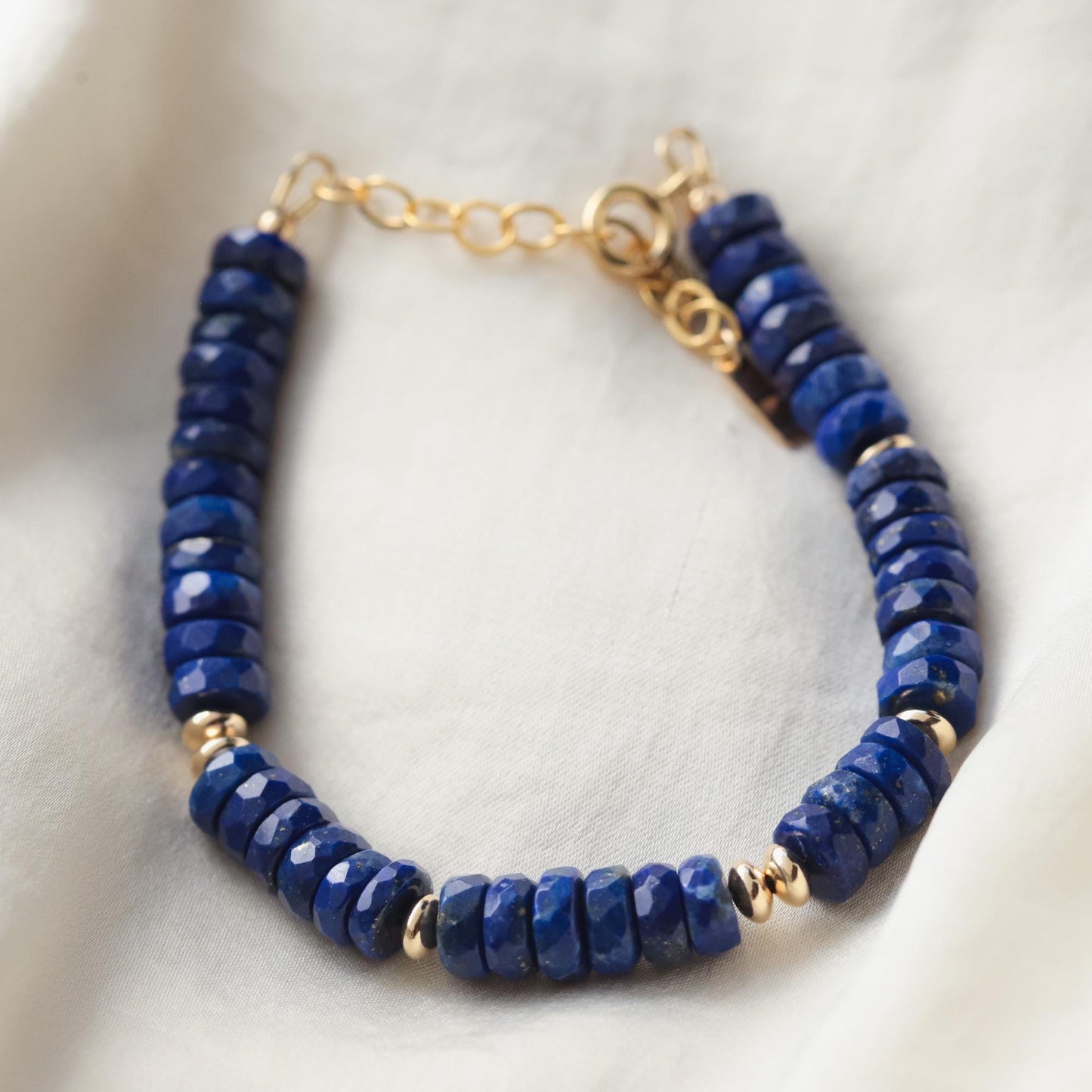 Deep blue lapis lazuli bracelet with polished round beads from Earthly Abundance, showcasing vibrant blue stones with gold-toned accents.
