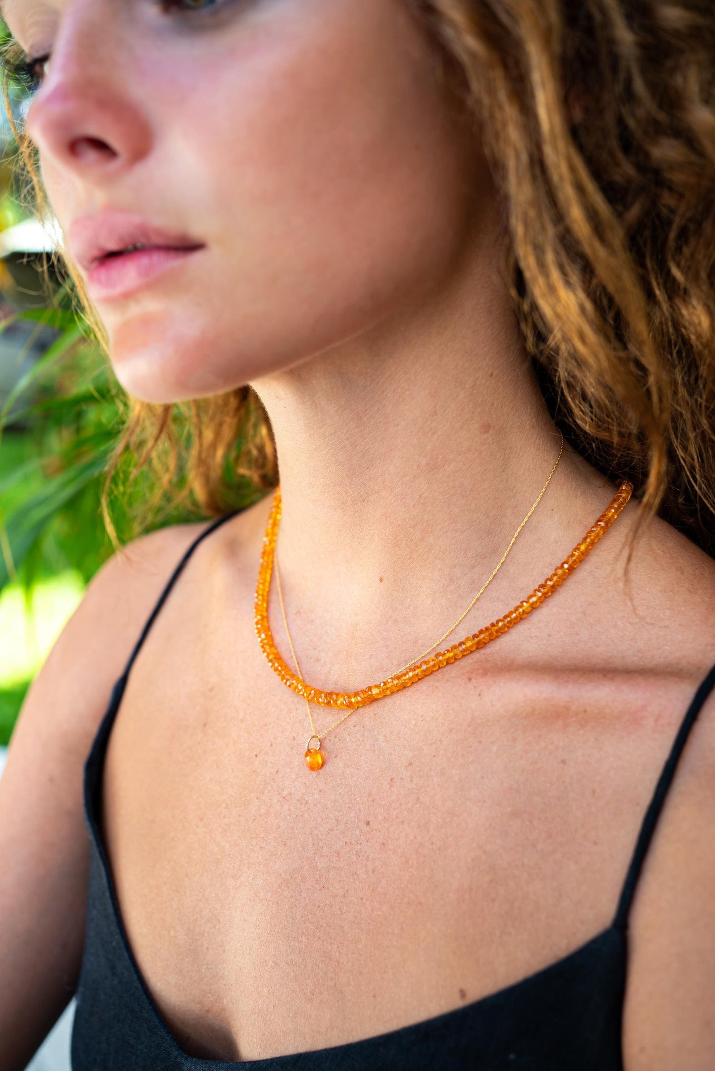 Mexican fire opal pendant necklace in 14K gold with a vibrant, fiery gemstone on a delicate gold chain.
