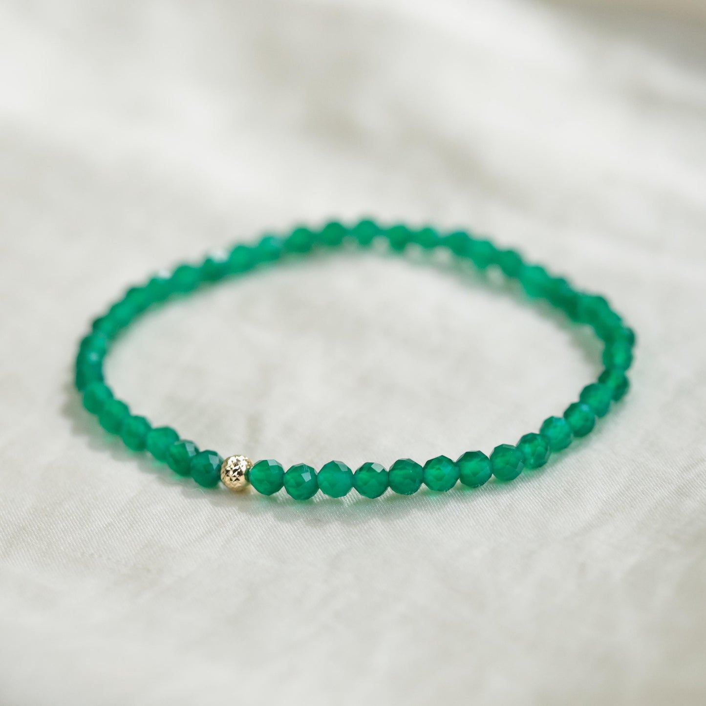 Green Onyx bracelet featuring polished beads from Earthly Abundance, displayed in a close-up shot highlighting its vibrant color and craftsmanship.