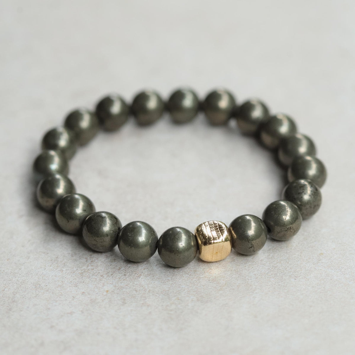 Earthly Abundance pyrite snake cube bracelet featuring a shiny, metallic snake-shaped design on a flexible bracelet band.