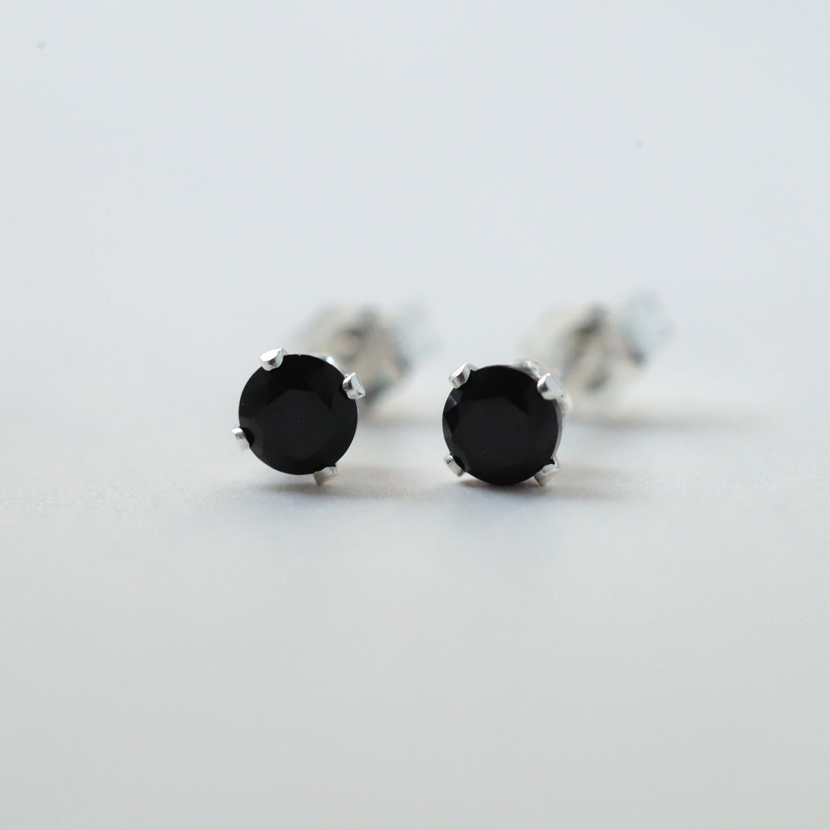 Black Spinel stud earrings by Earthly Abundance featuring round, faceted black gemstones set in silver posts.