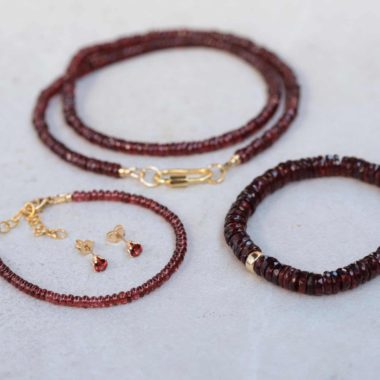 Earthly Abundance garnet Heishi bracelet with small red garnet beads on a delicate elastic cord.