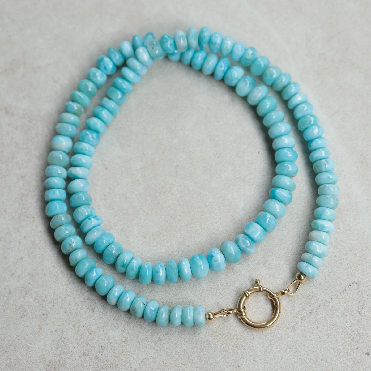 Earthly Abundance Tranquil Beauty Larimar Necklace with 14K gold chain, featuring a smooth blue larimar pendant on a delicate chain