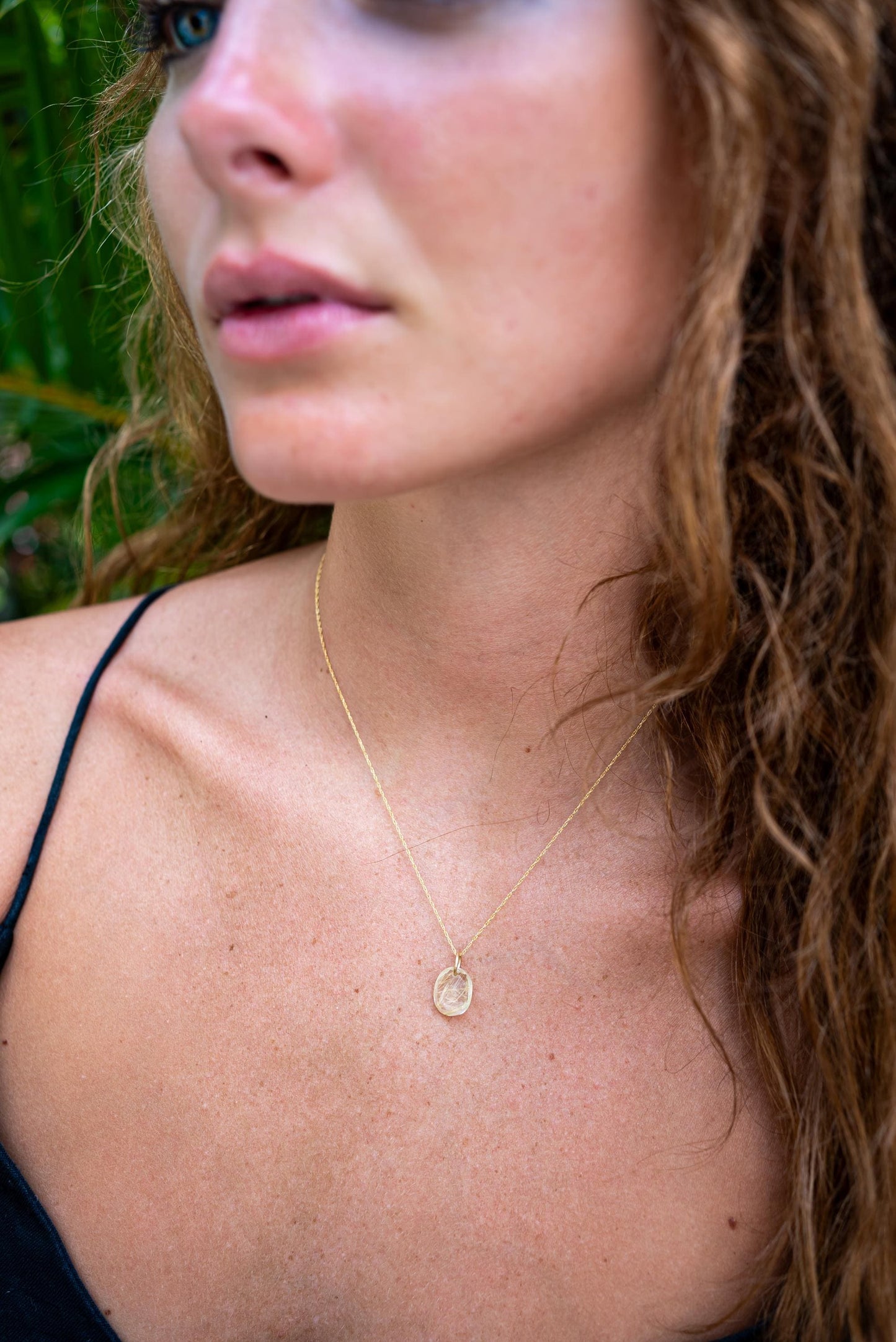 Rutilated Quartz pendant necklace with 14K gold setting, featuring a polished gemstone on a delicate chain.