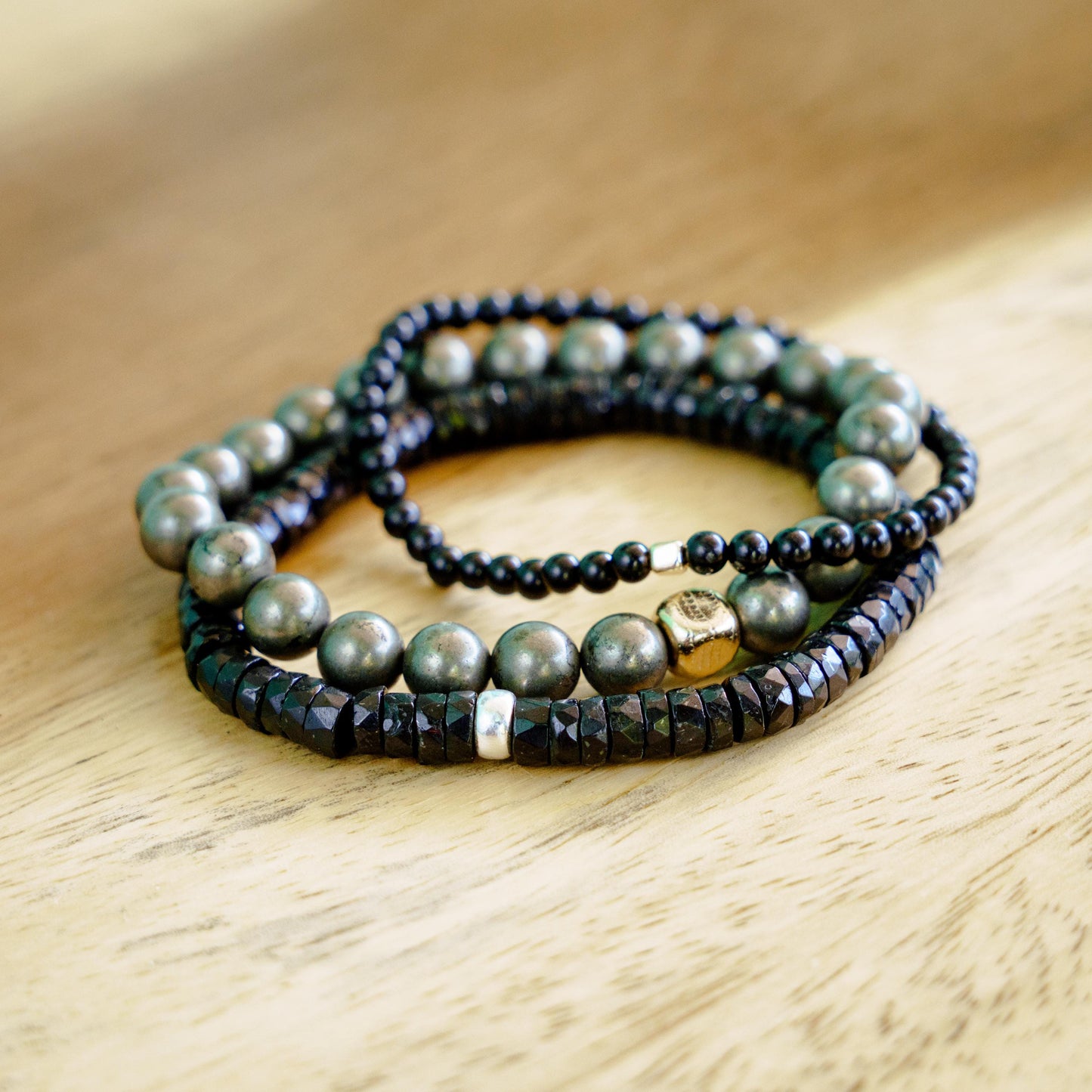 Earthly Abundance Pyrite Snake Cube bracelet with intricate cube and snake design in shiny metallic finish.