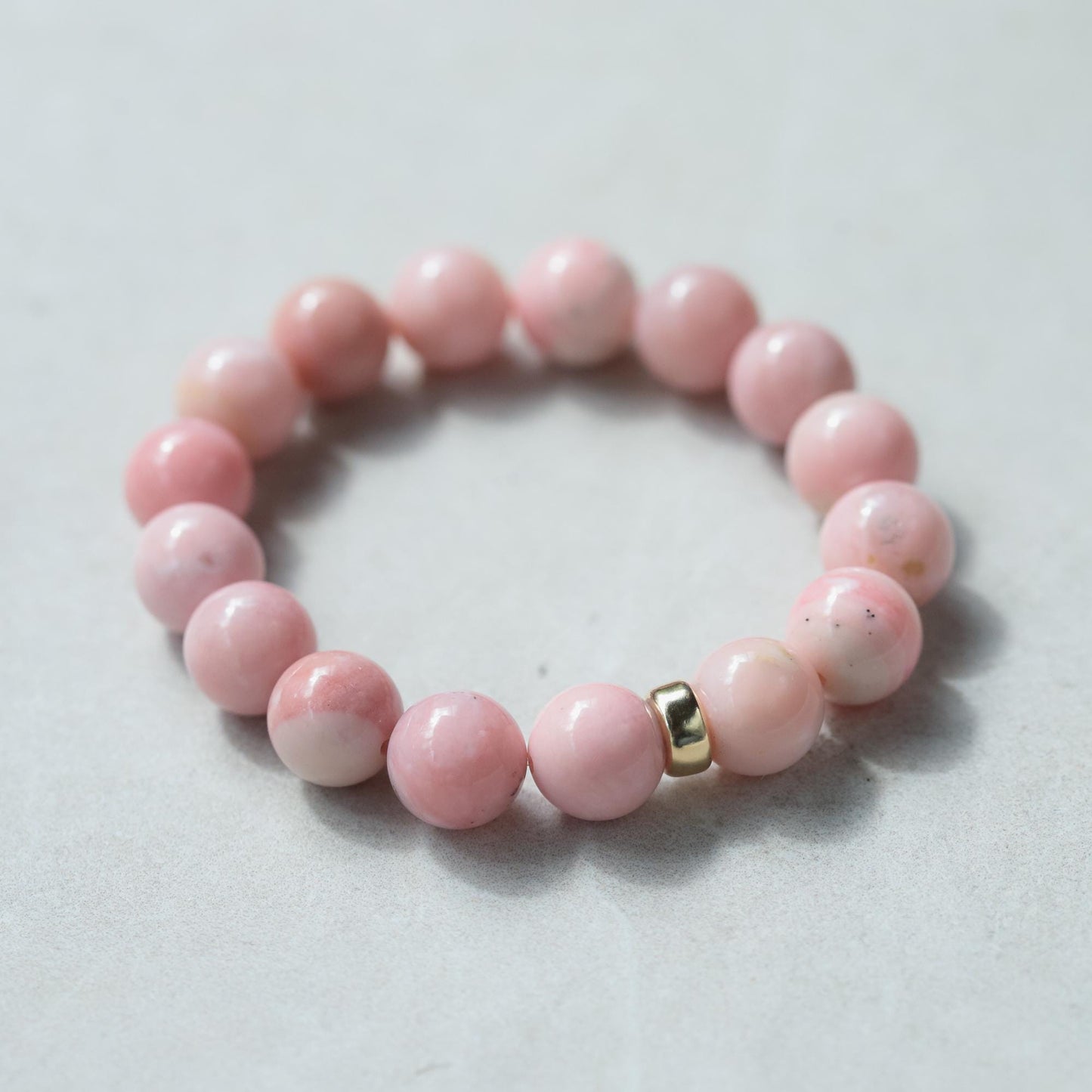 Pink Opal bracelet with 12mm beads featuring a 14K gold clasp by Earthly Abundance, displayed on a soft neutral background.